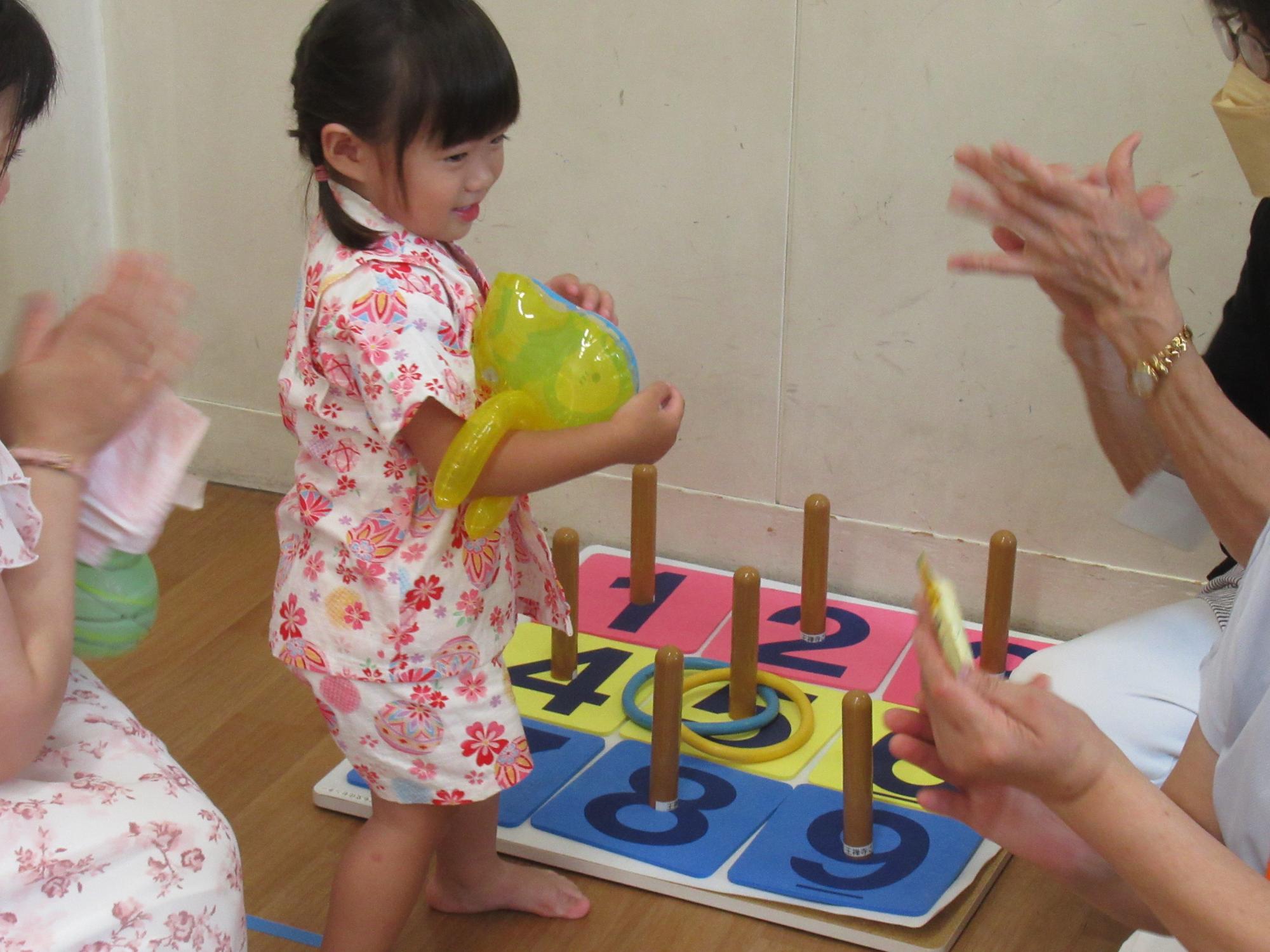 こどもが輪投げゲームをしている写真
