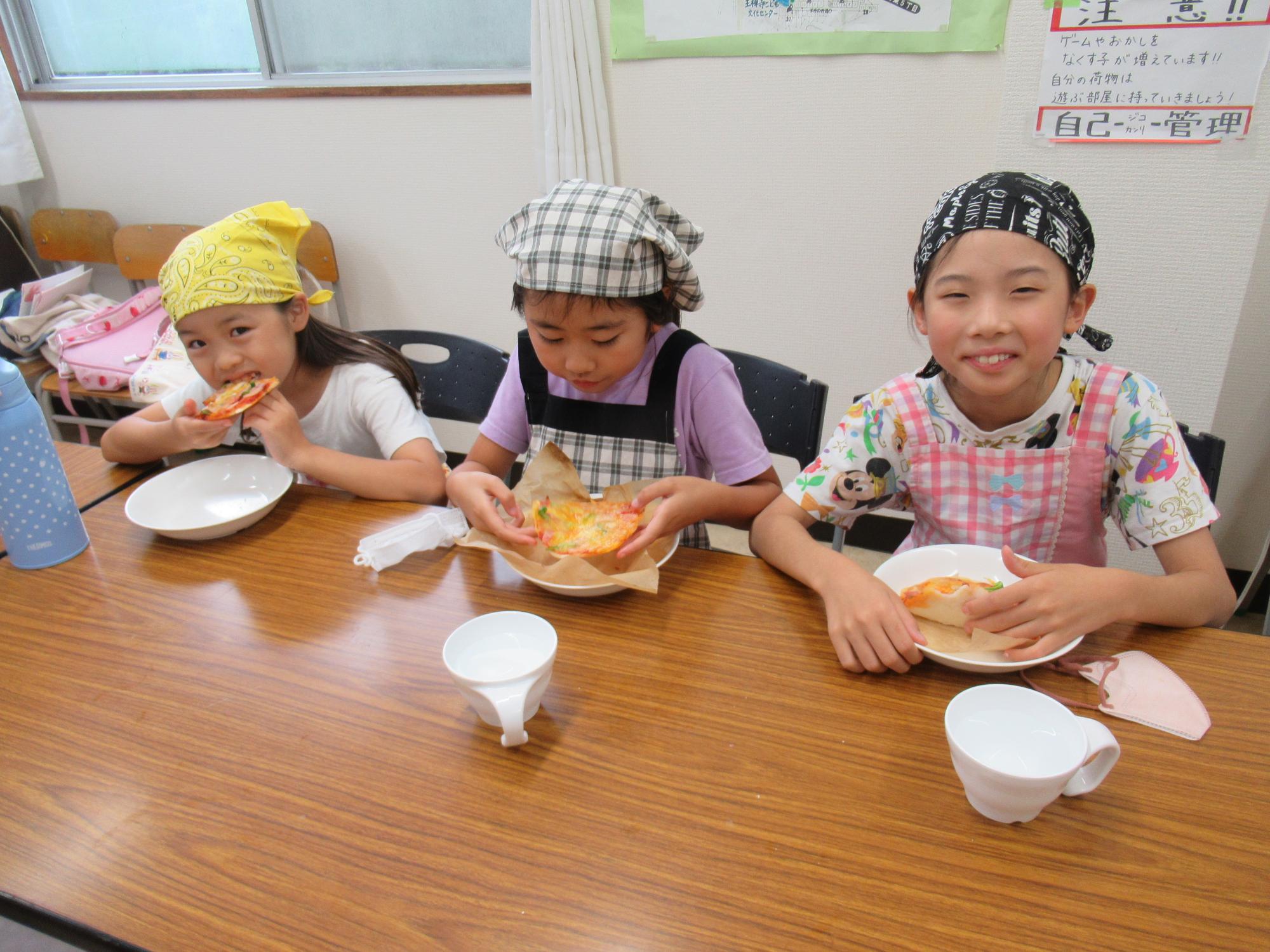 完成した米粉ピザを食べている子ども達の写真