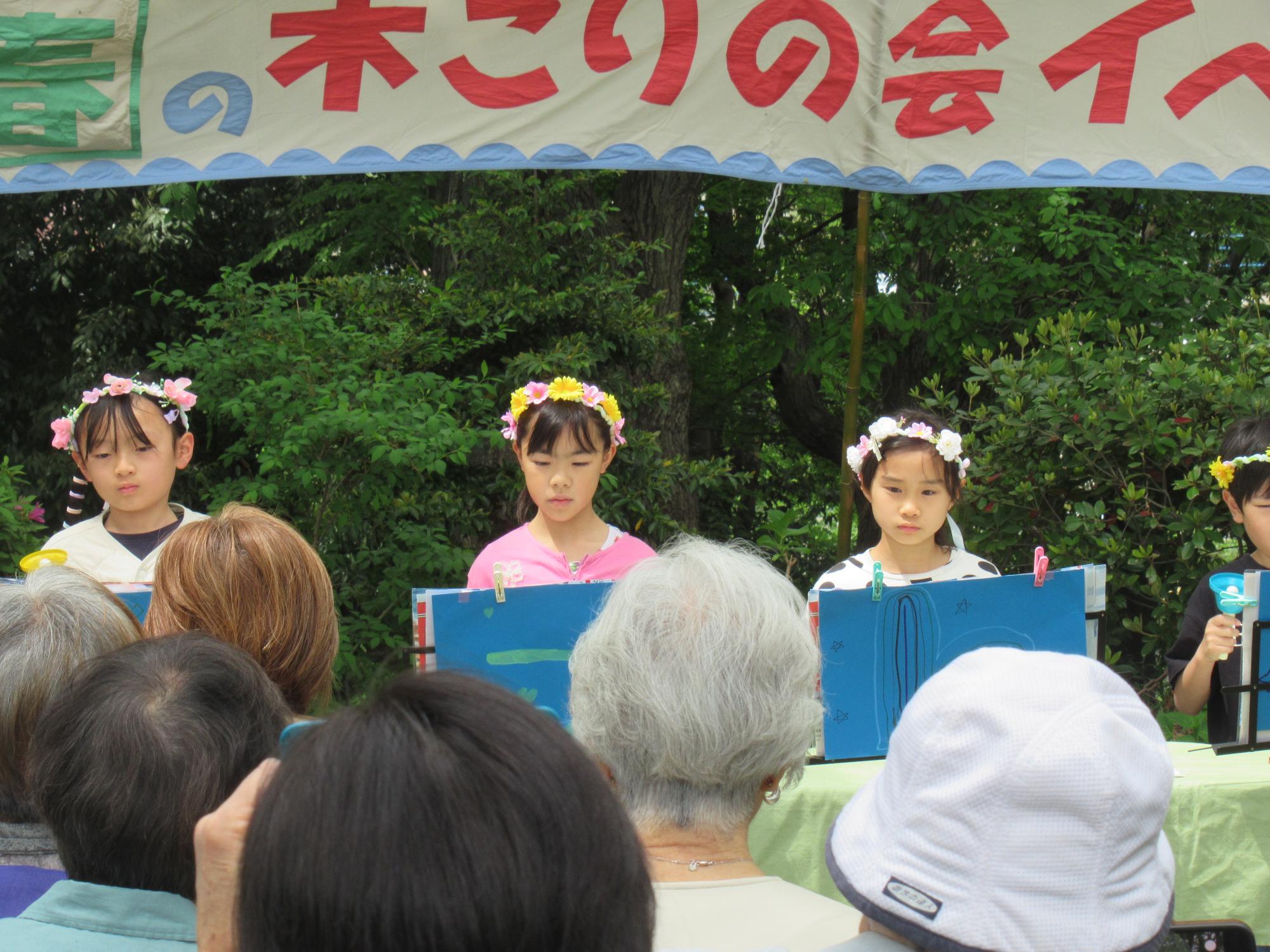 一生懸命ハンドベルの演奏をする子どもたちと職員の写真