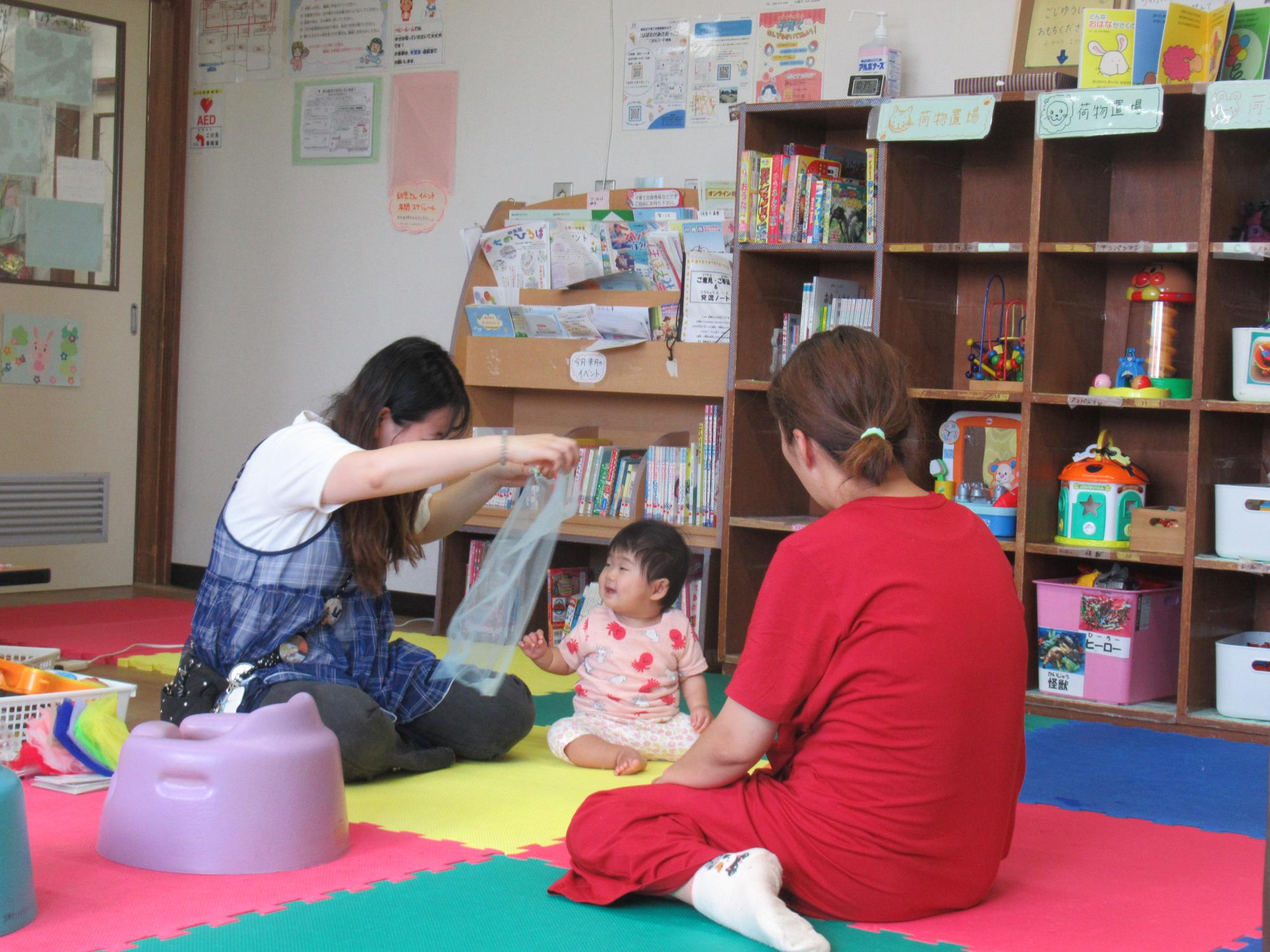 講師が幼児とスカーフをで遊ぶ様子の写真