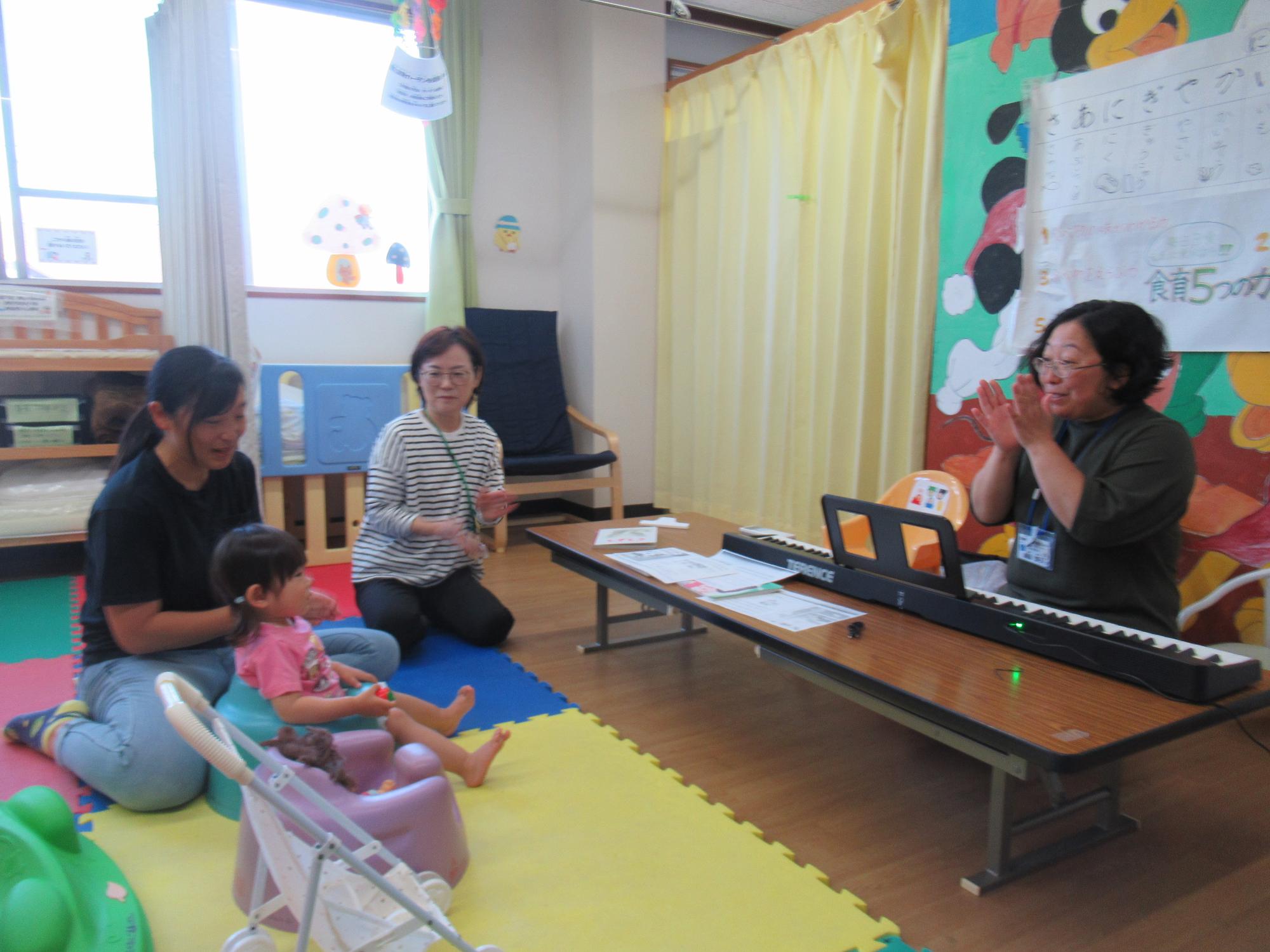 幼児親子と職員がお誕生日会をしている写真