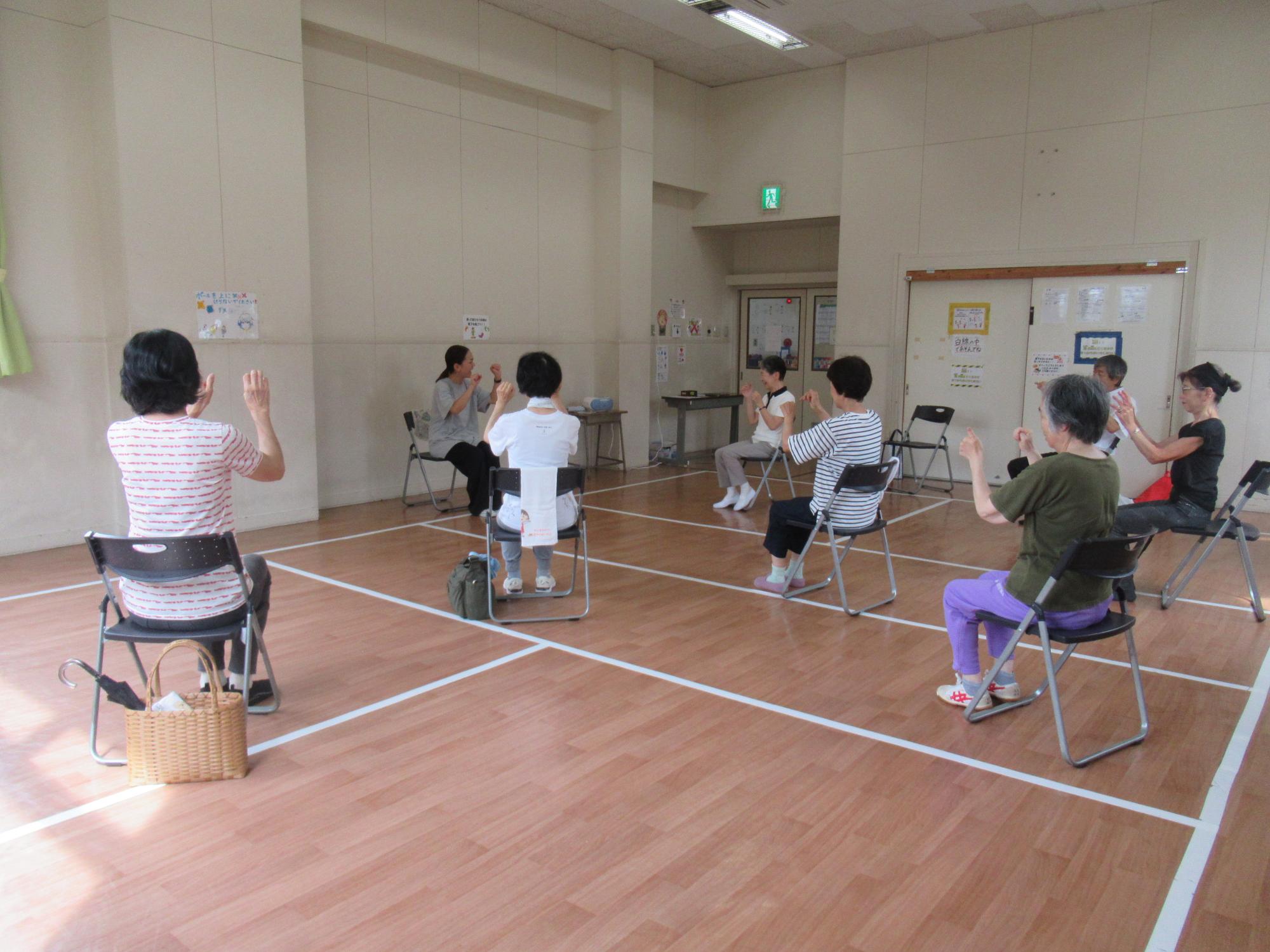 地域の皆さんが椅子に座って体操している様子