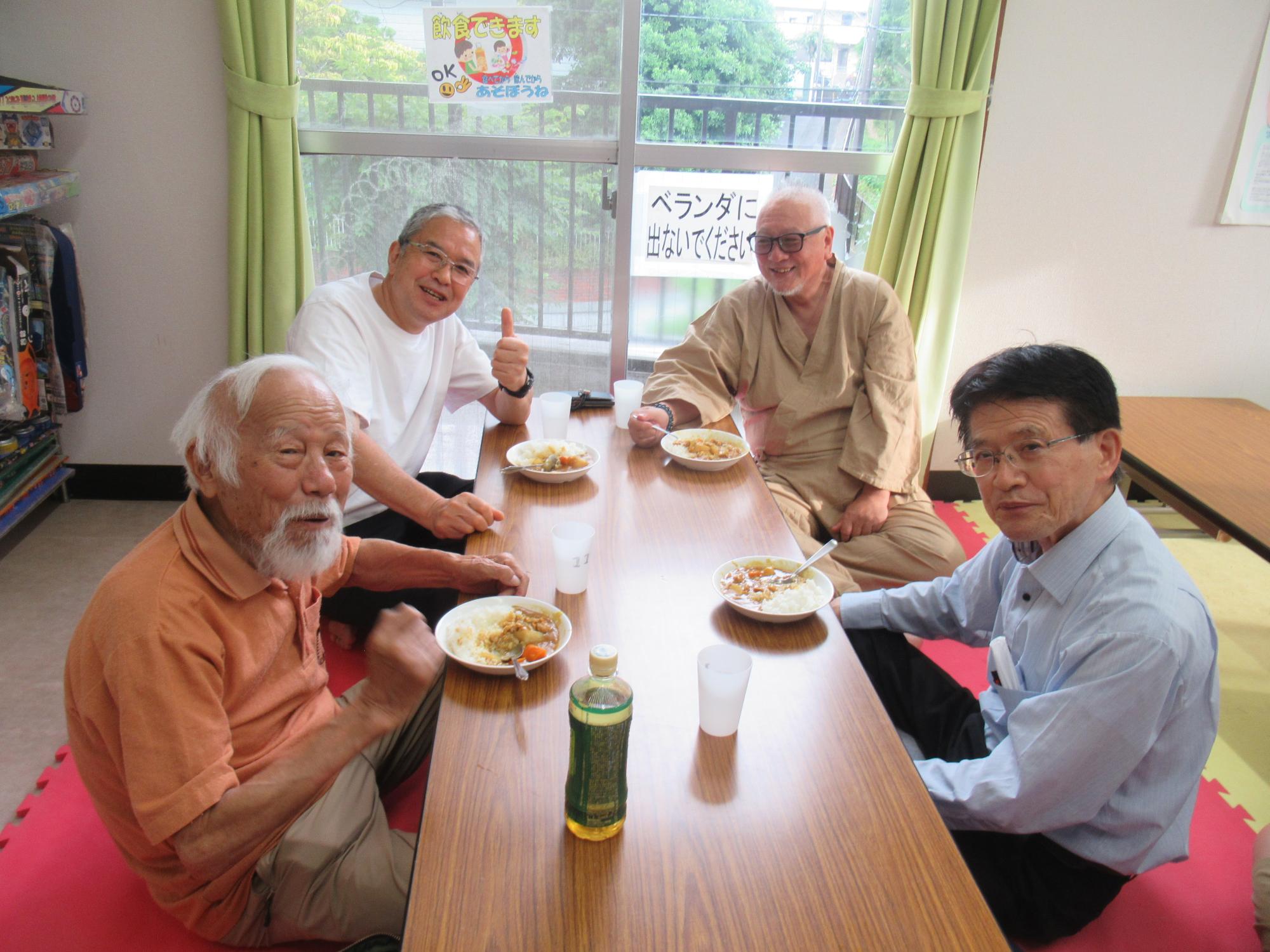 地域の方々がカレーを食べている写真