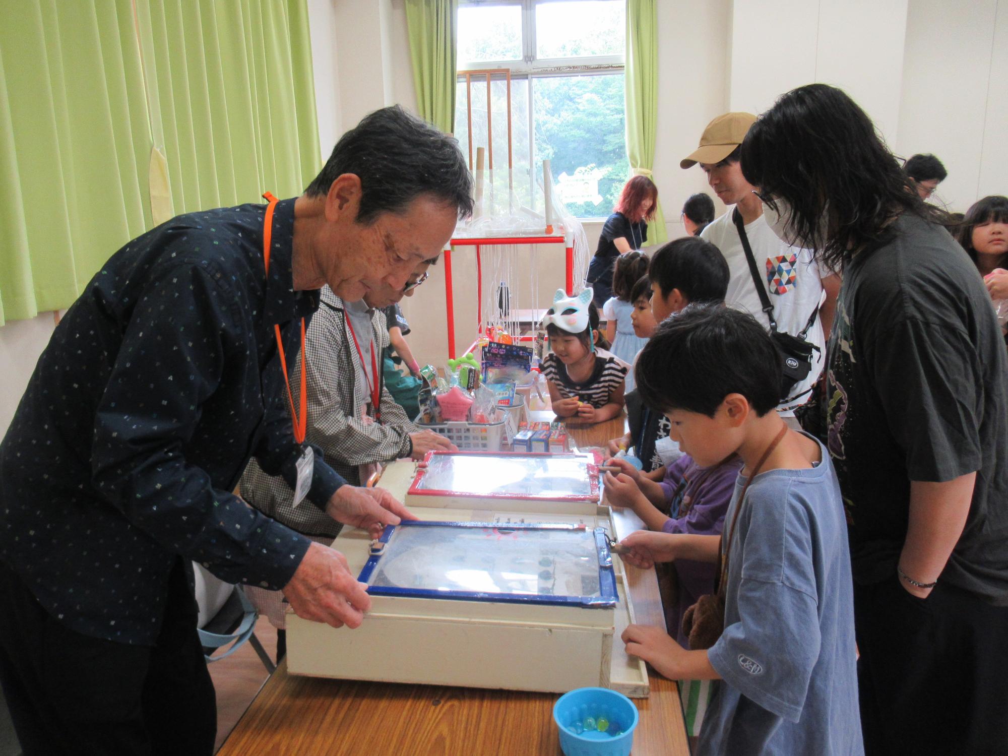 スマートボールのブースと小学生の写真