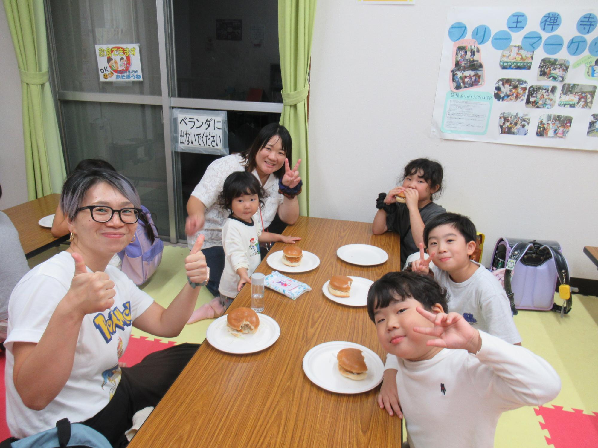 メンチカツバーガーを食べる親子の写真