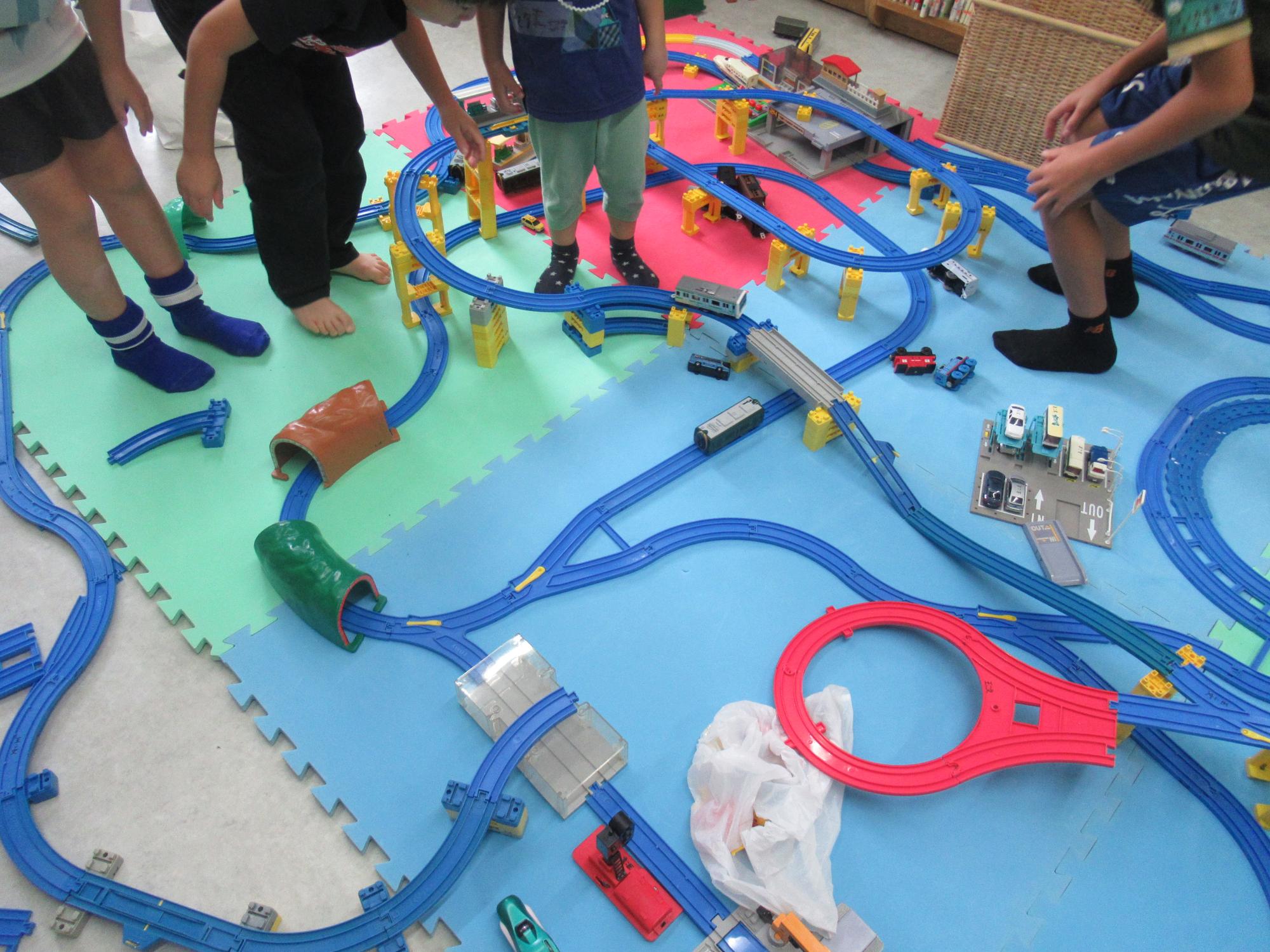 プラレールをつなげて大きな線路を作っている様子