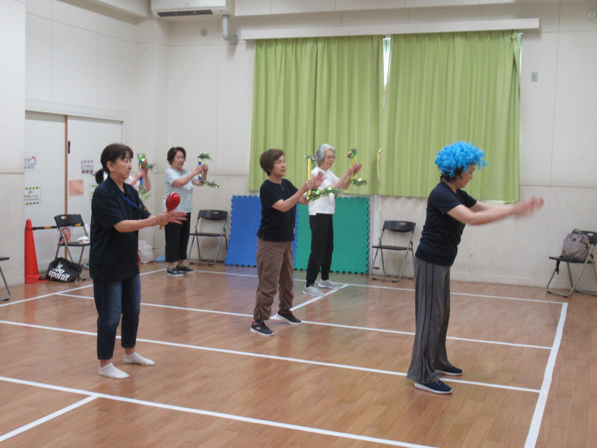 音楽に合わせてダンスをする講師と参加者の写真