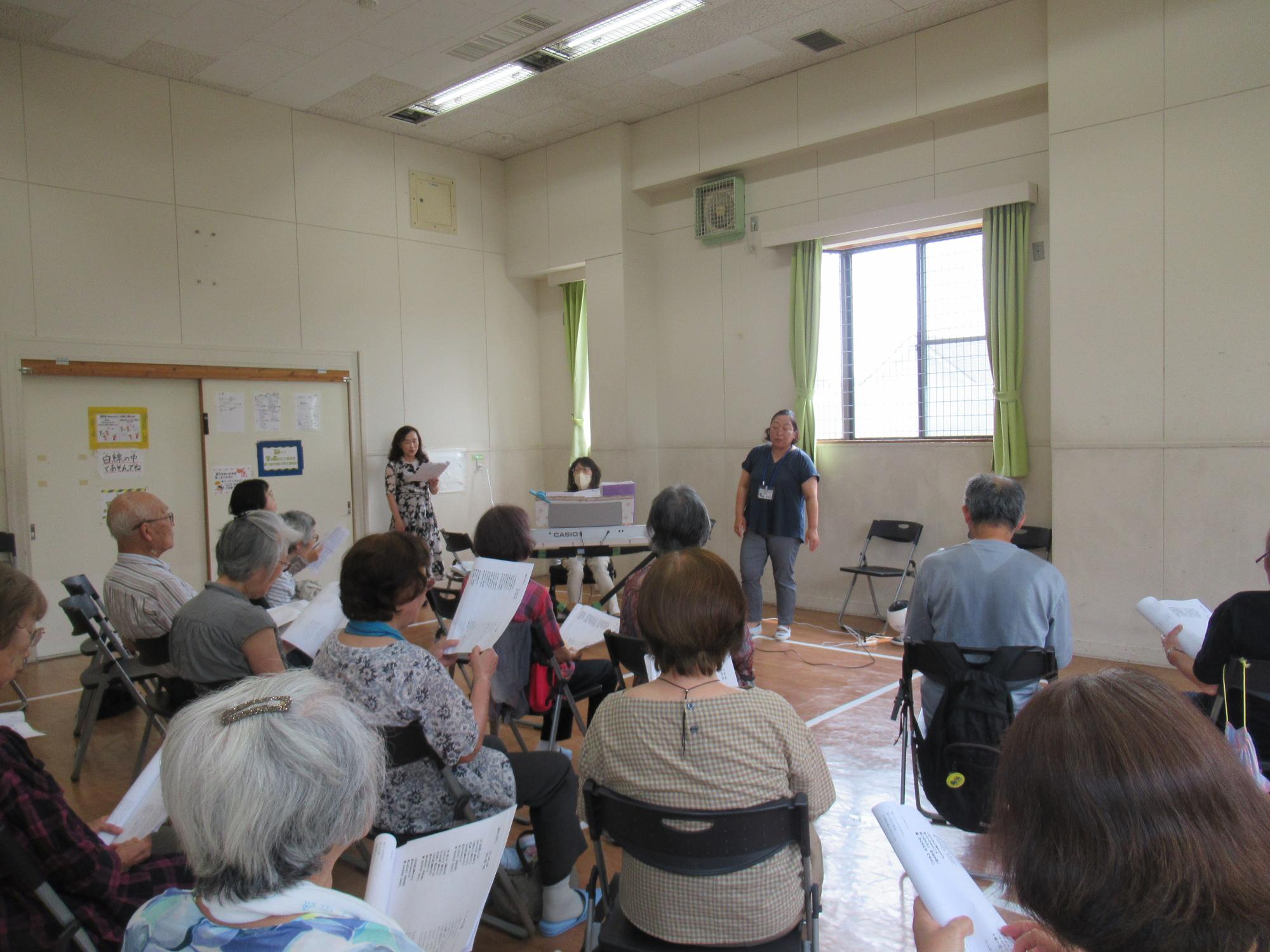 講師の演奏に合わせて歌を歌う参加者の様子