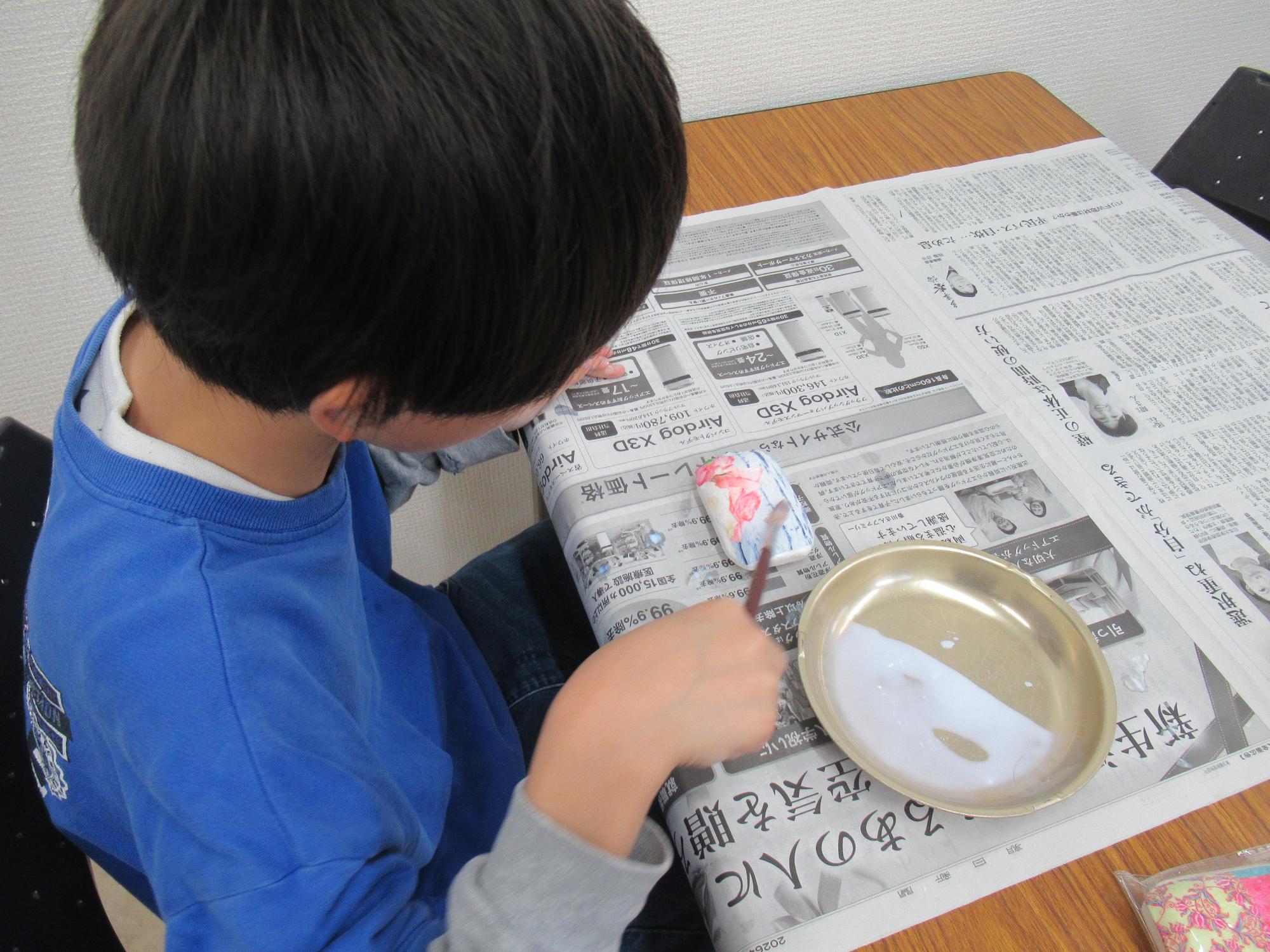 せっけんのデコパージュを作る子どもの写真