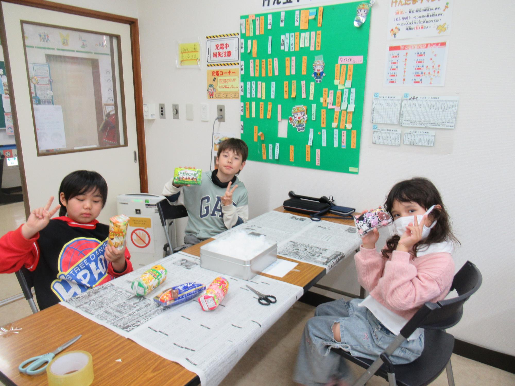 自分で作っお菓子のスクイーズを持ってポーズをとる子どもたちの写真
