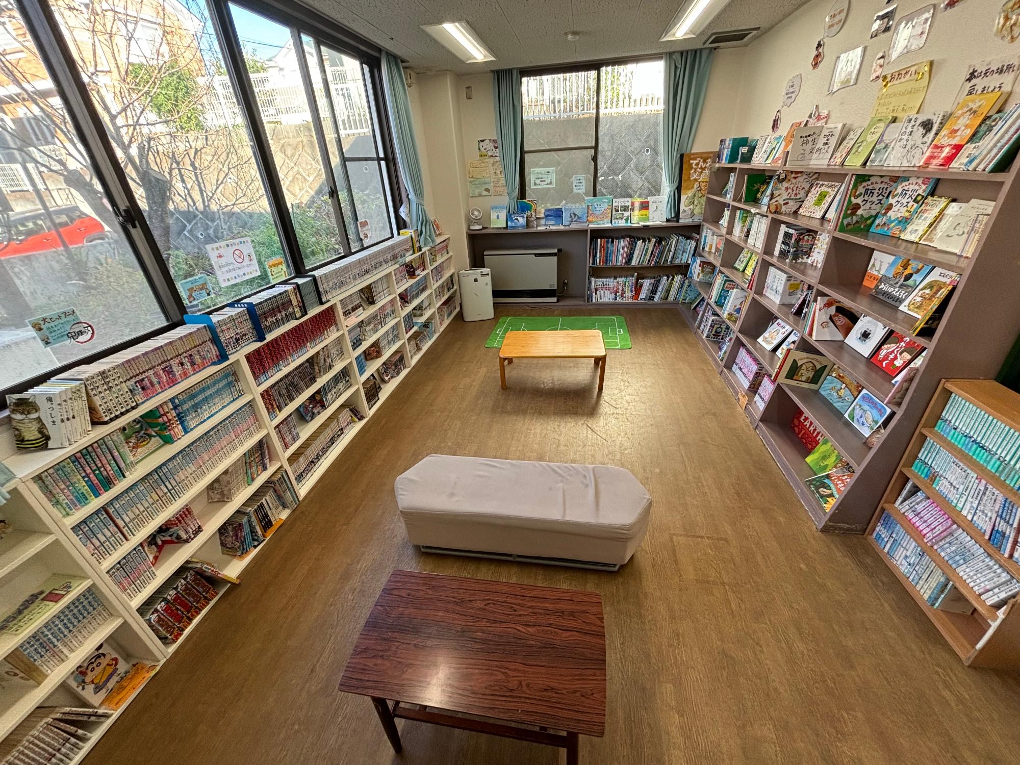フローリングで本棚に沢山の本が並べられた図書室の写真
