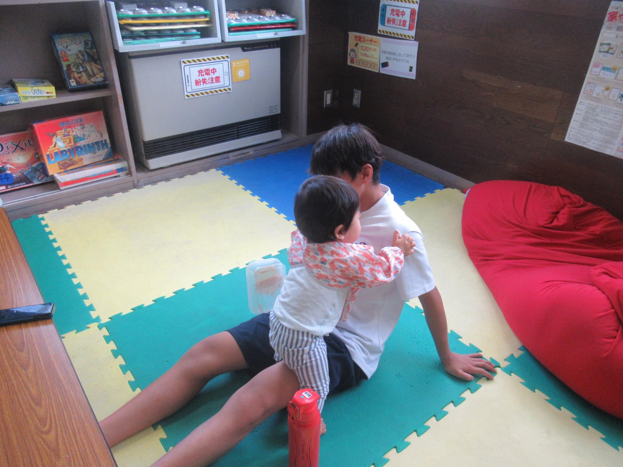 幼児が中学生に抱っこされている写真