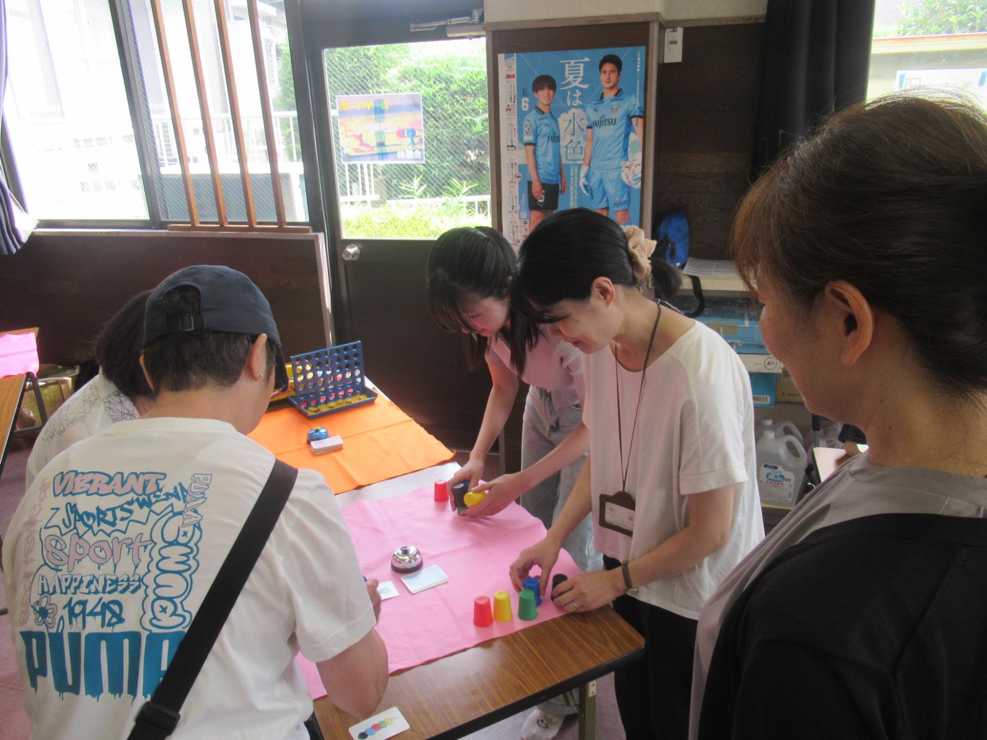大学生とボードゲームをしている参加者の写真