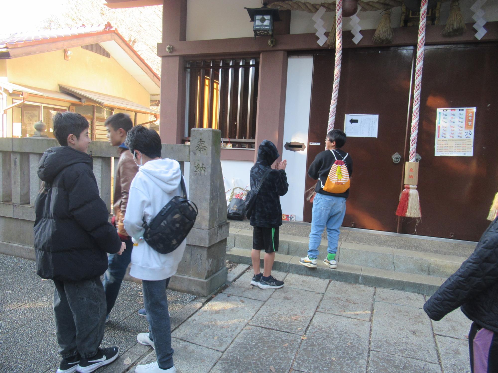 神社にお参りをしている子どもの写真