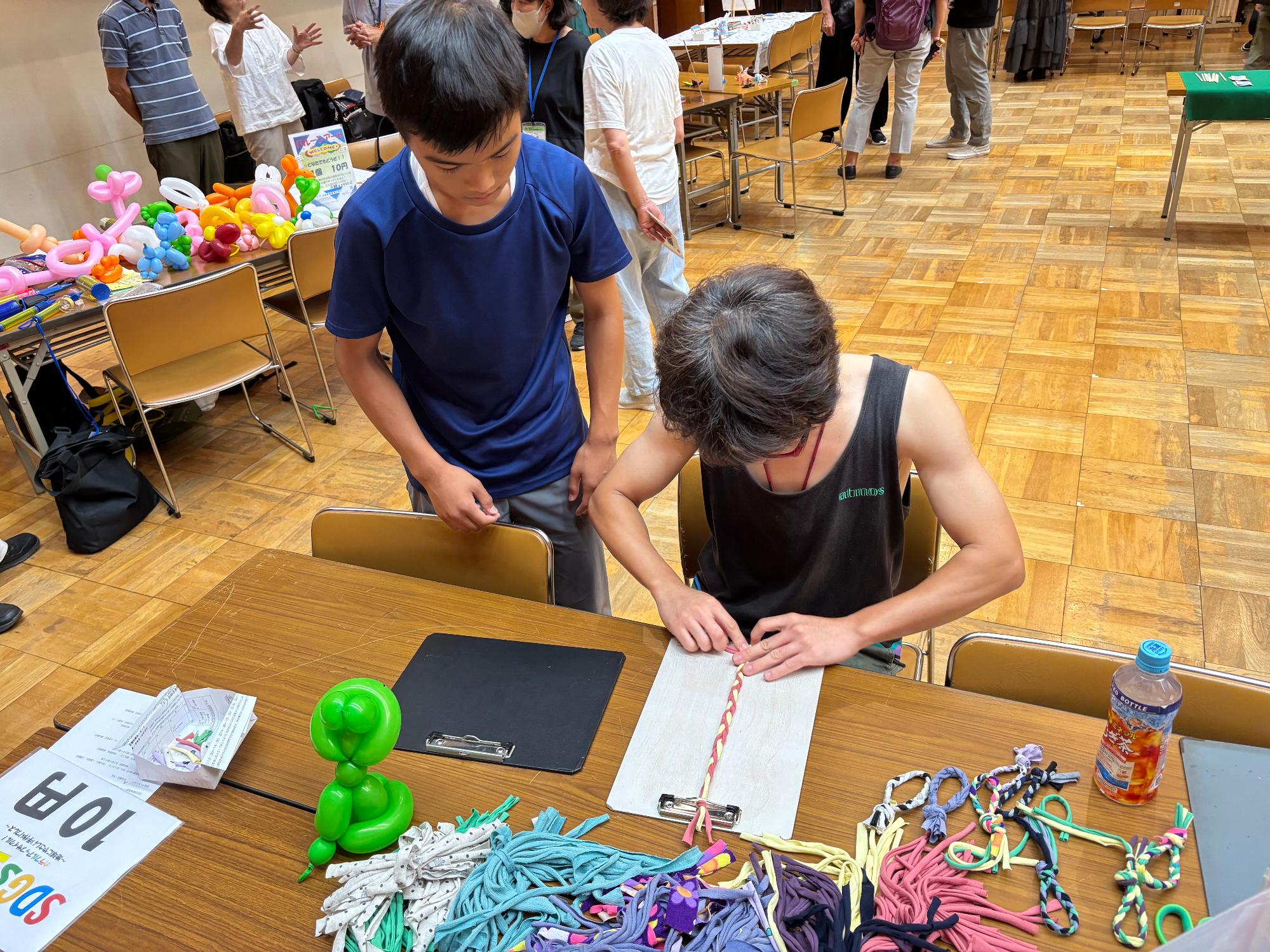 ブレスレットを教えている中学生の写真