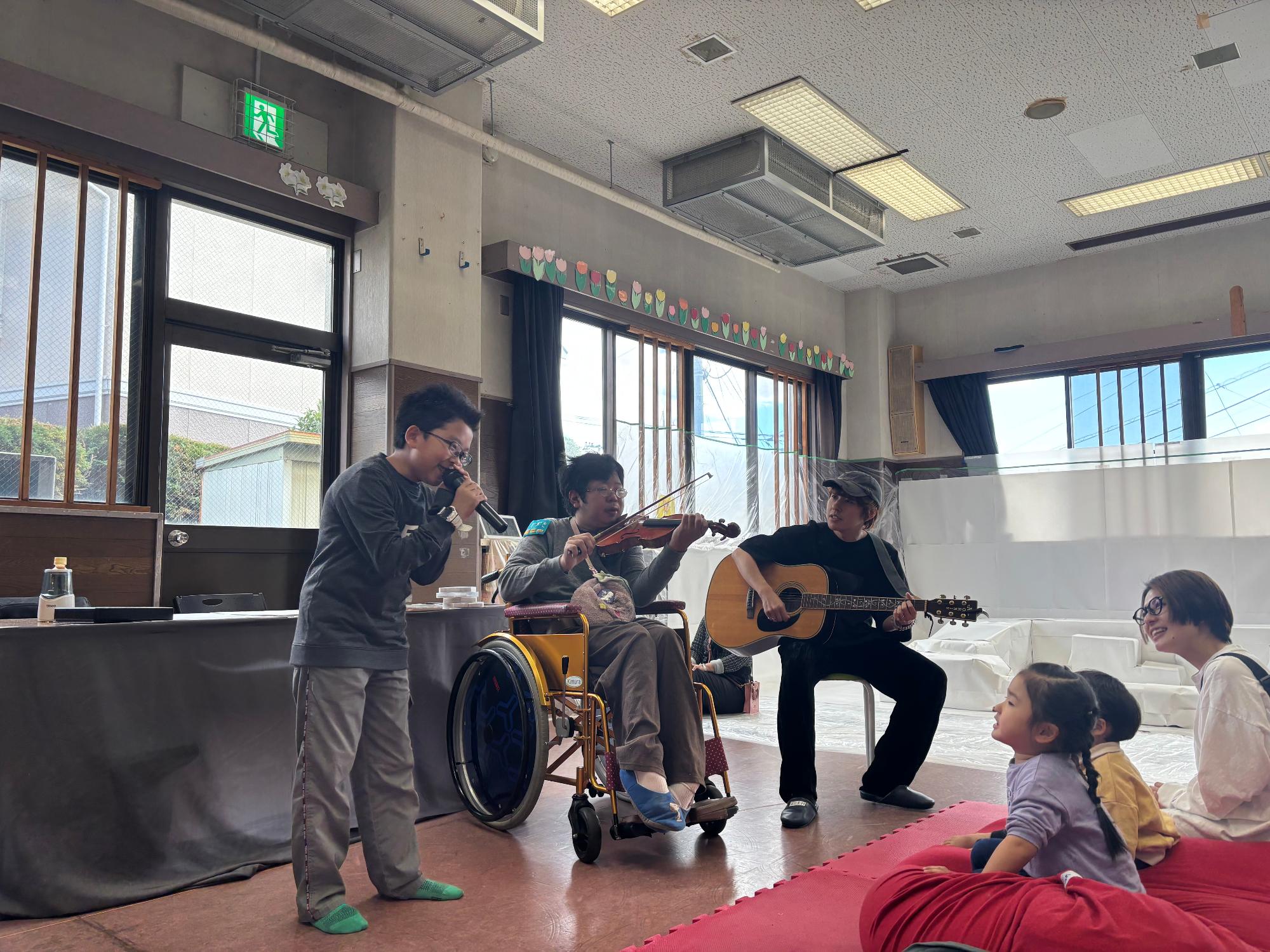 子どもと2人の講師が歌っている写真