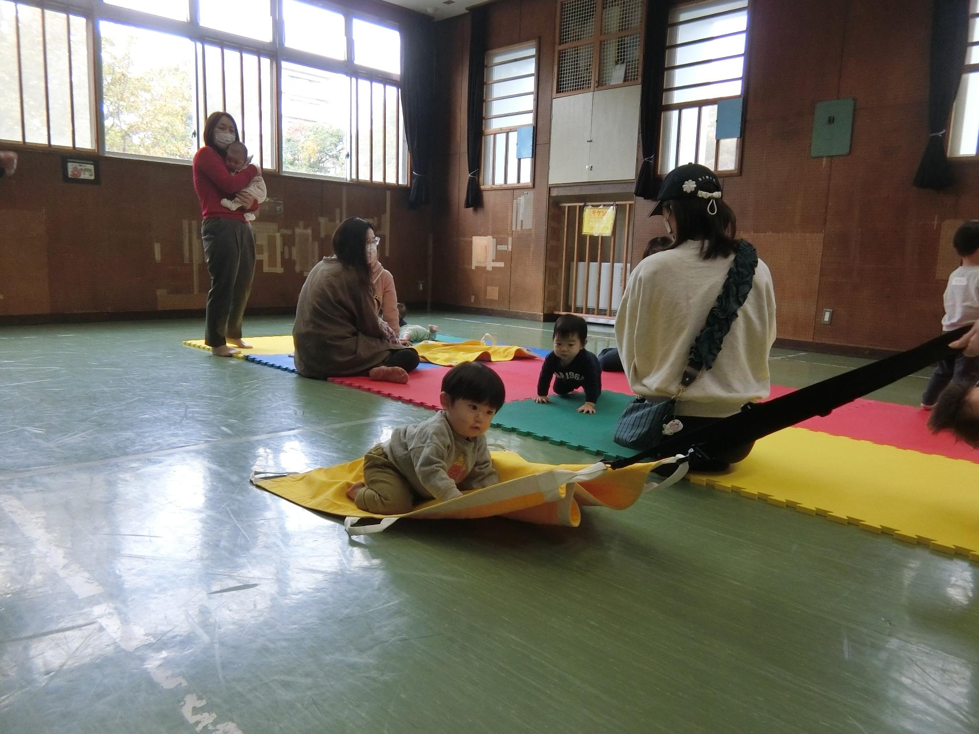 赤ちゃんを乗せた布を滑らせている様子