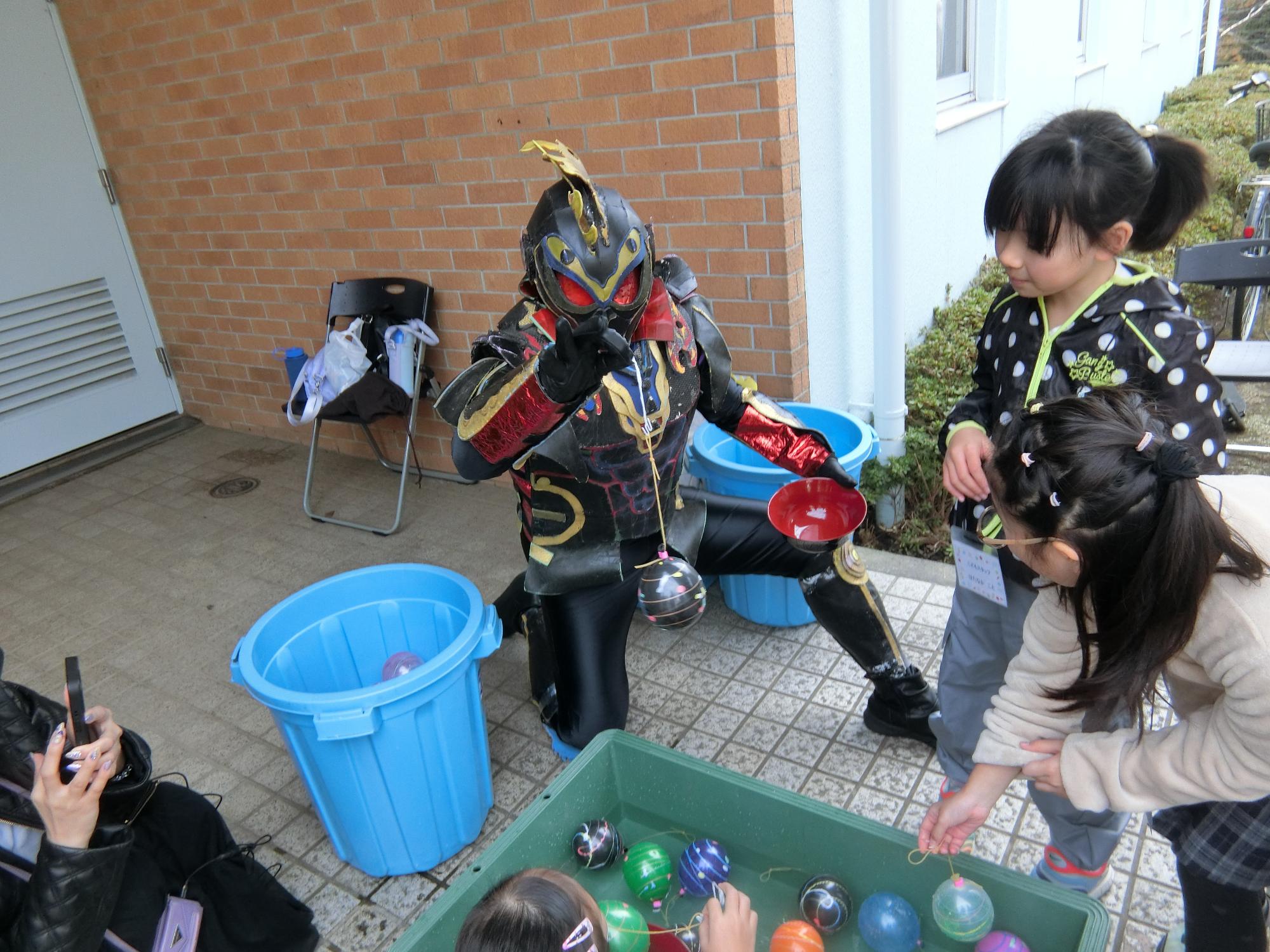 カキライザー、ヤミライザーがヨーヨーつりをしている様子