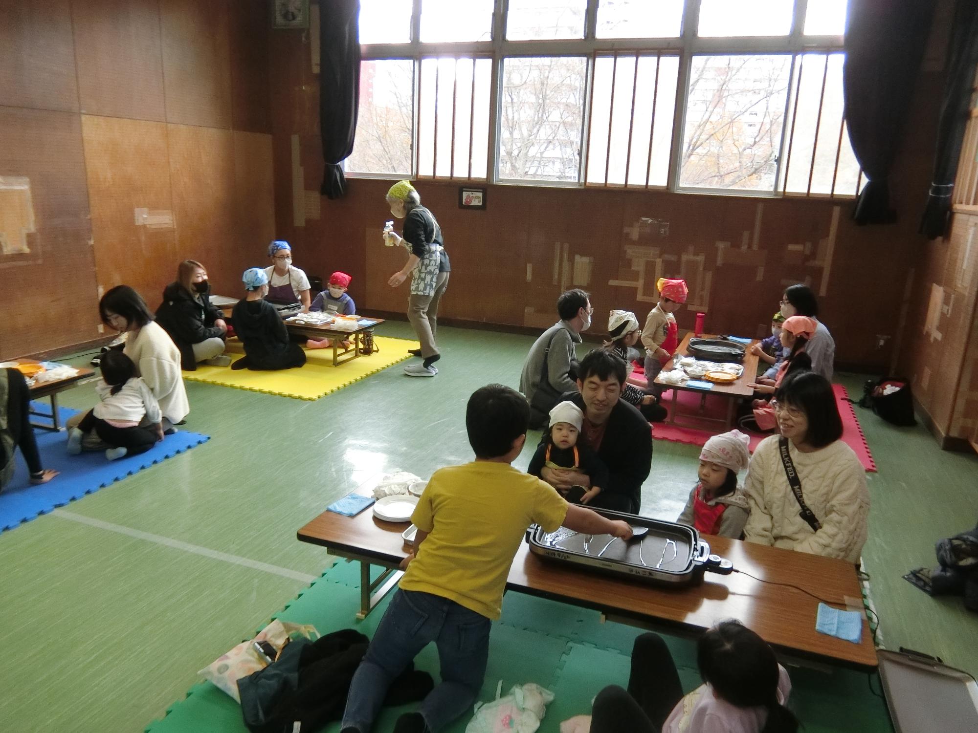 参加者が4つのグループに分かれてホットプレートを囲んでいる様子