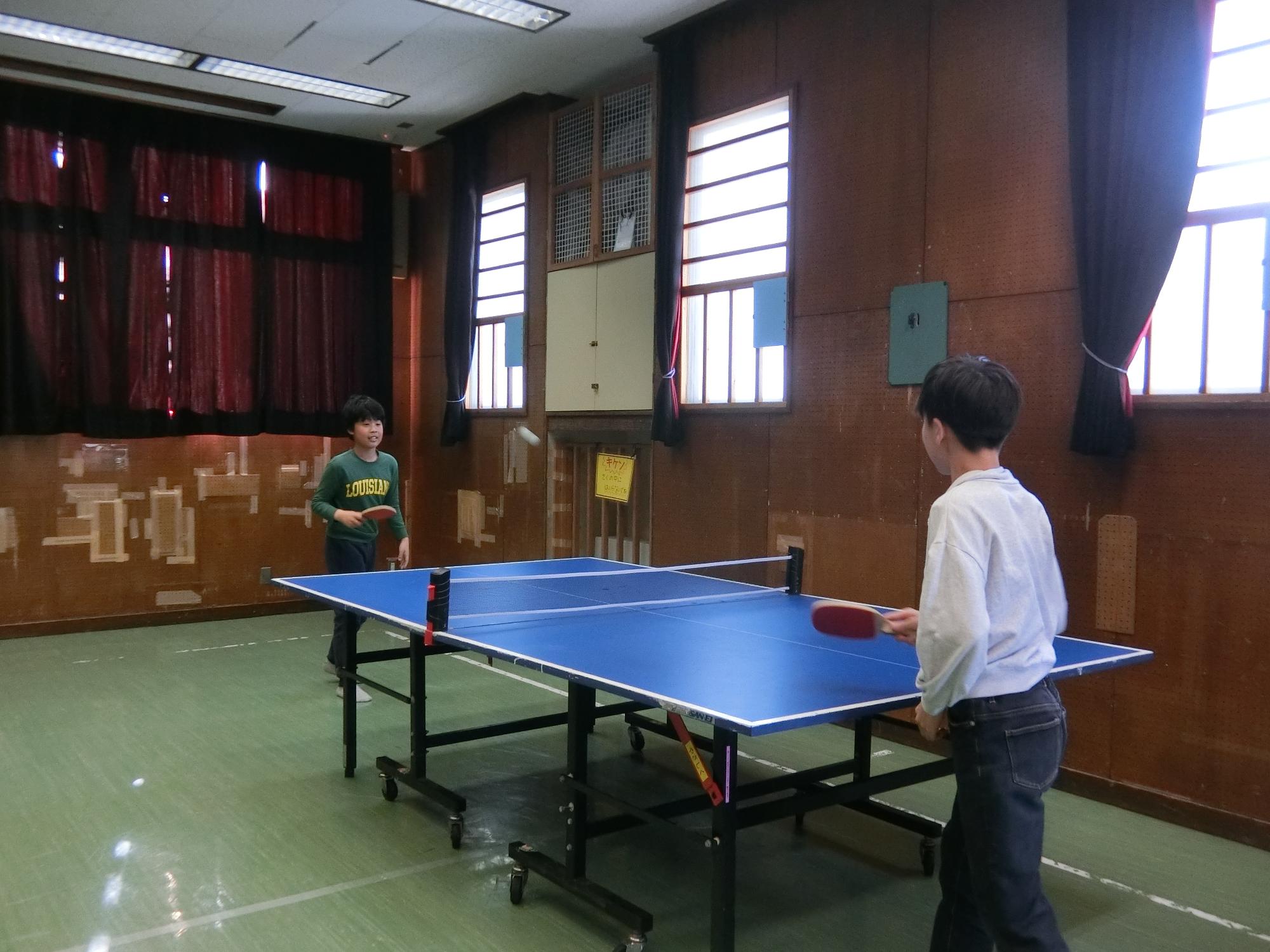 小学生が卓球でラリーをしている様子