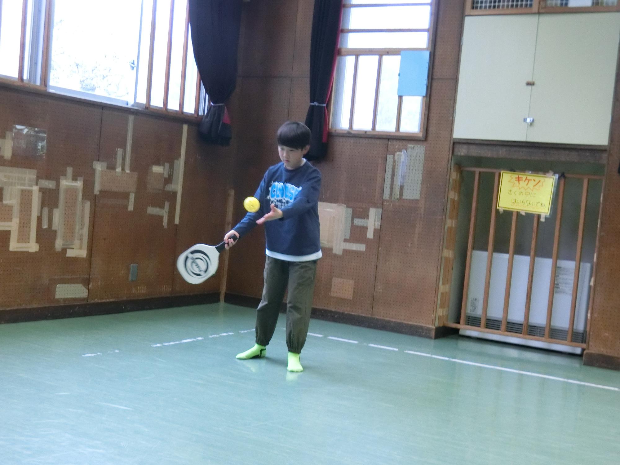 小学生がサーブを打っている様子