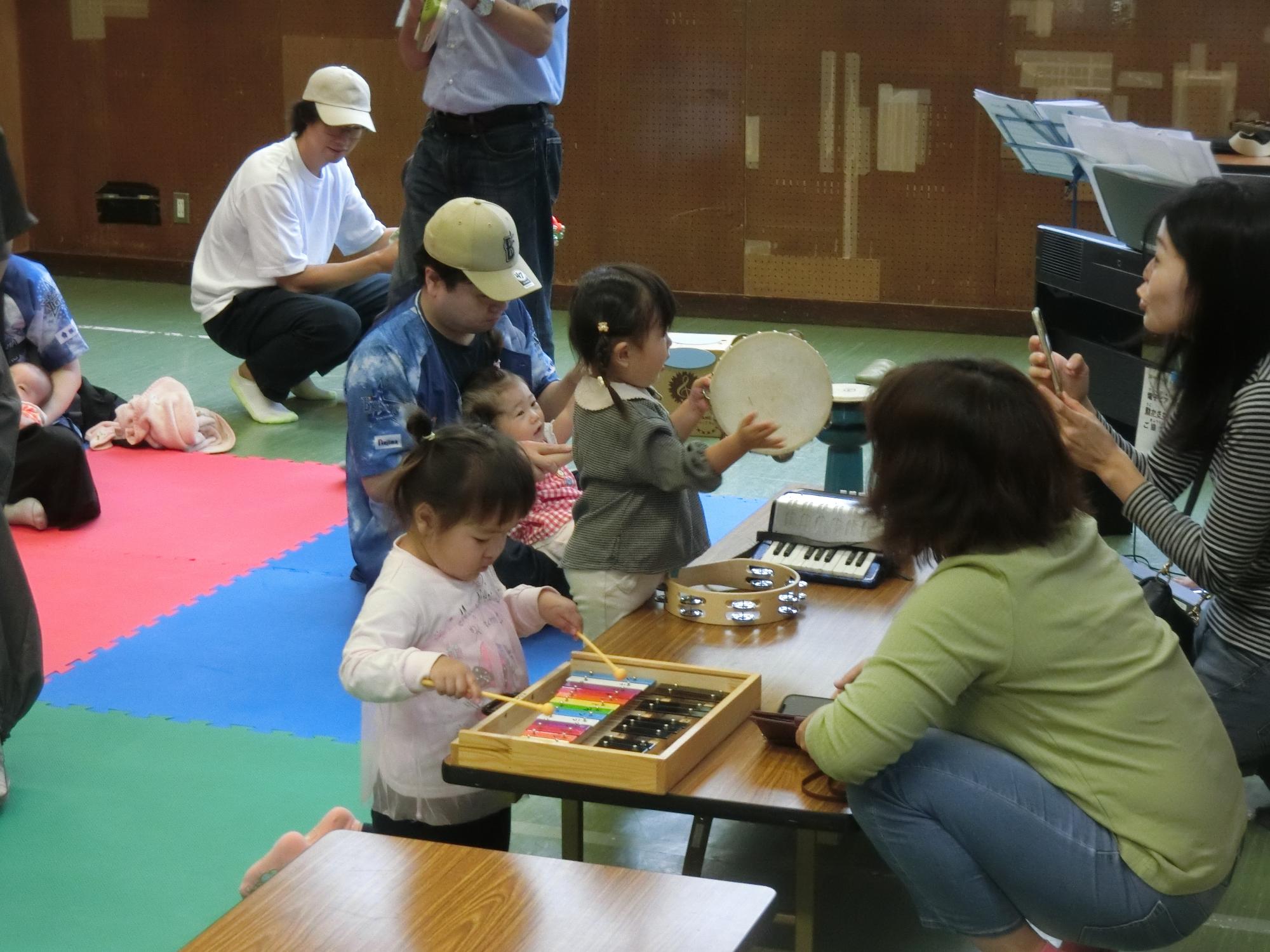 幼児親子が楽器を使って演奏を楽しんでいる様子