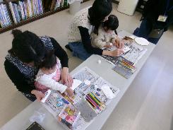 紙皿に折り紙をはっている様子