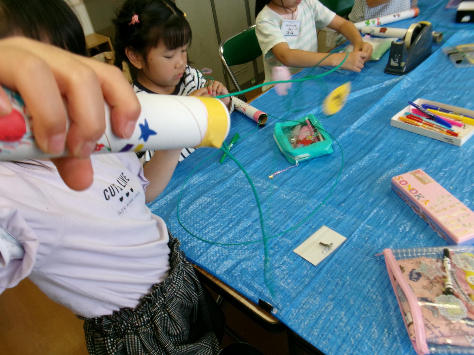 ながい筒に針金をつけて、パーツをひっかけすべらせてジェットコースターができました