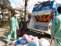 スケルトン車にゴミの投げ入れ体験をしている写真