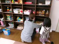 乳幼児室のおもちゃ棚を拭いて整理している写真