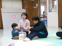 中学生と幼児親子が一緒に手遊びをしていることろ