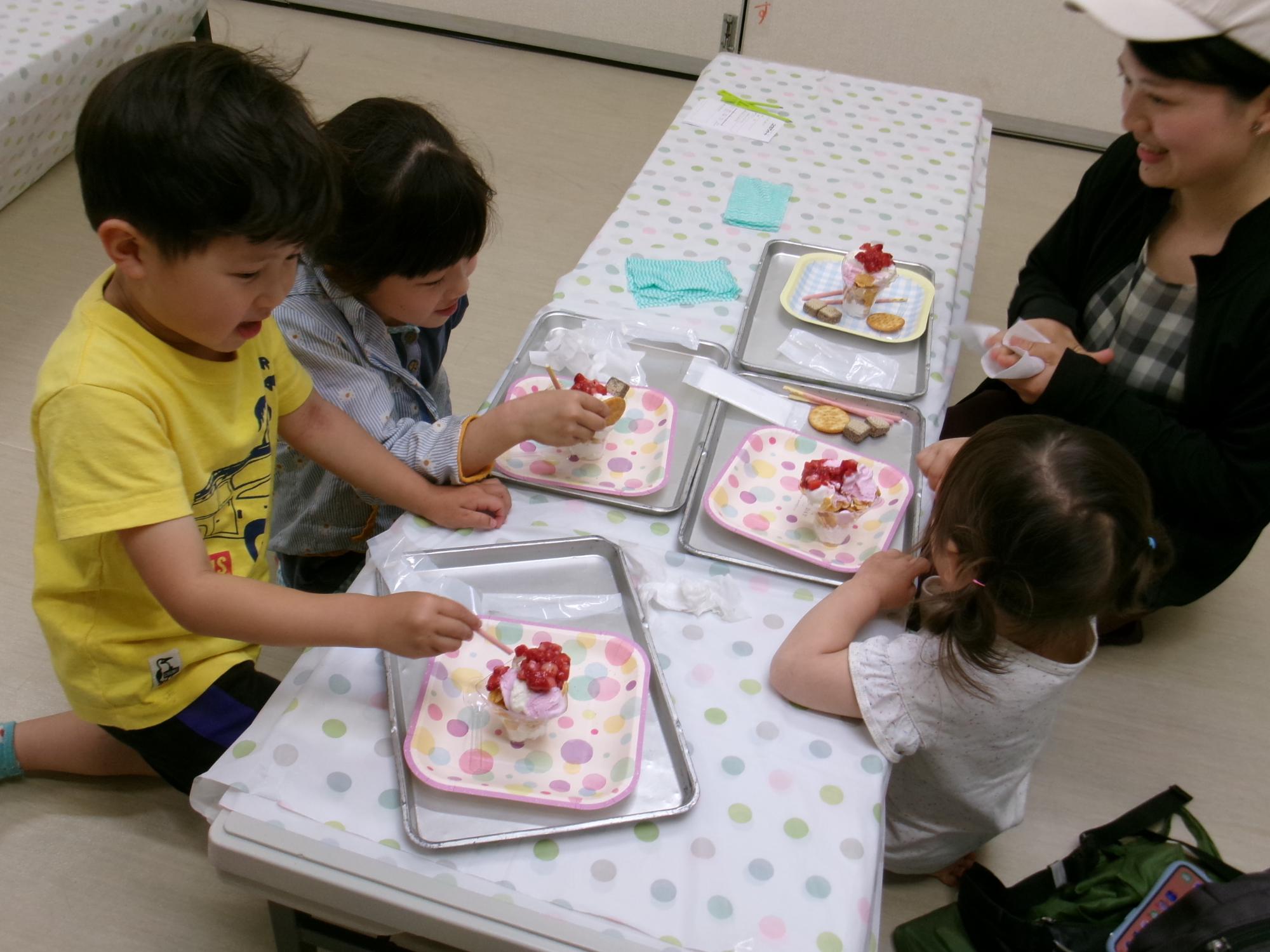 パフェを食べる幼児家族の様子の写真