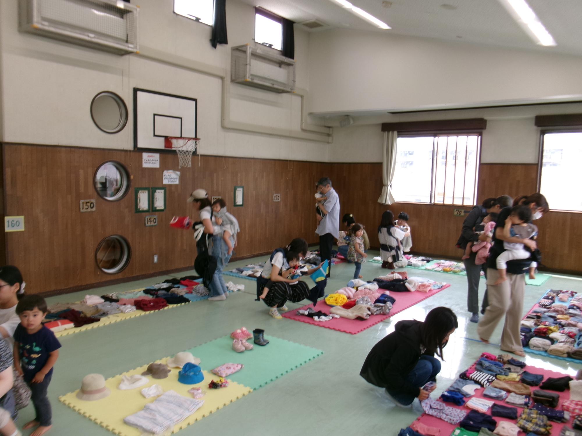 集会室で実施した「ちびっこマルシェ」にて洋服のお譲り会に参加する利用者の様子の写真