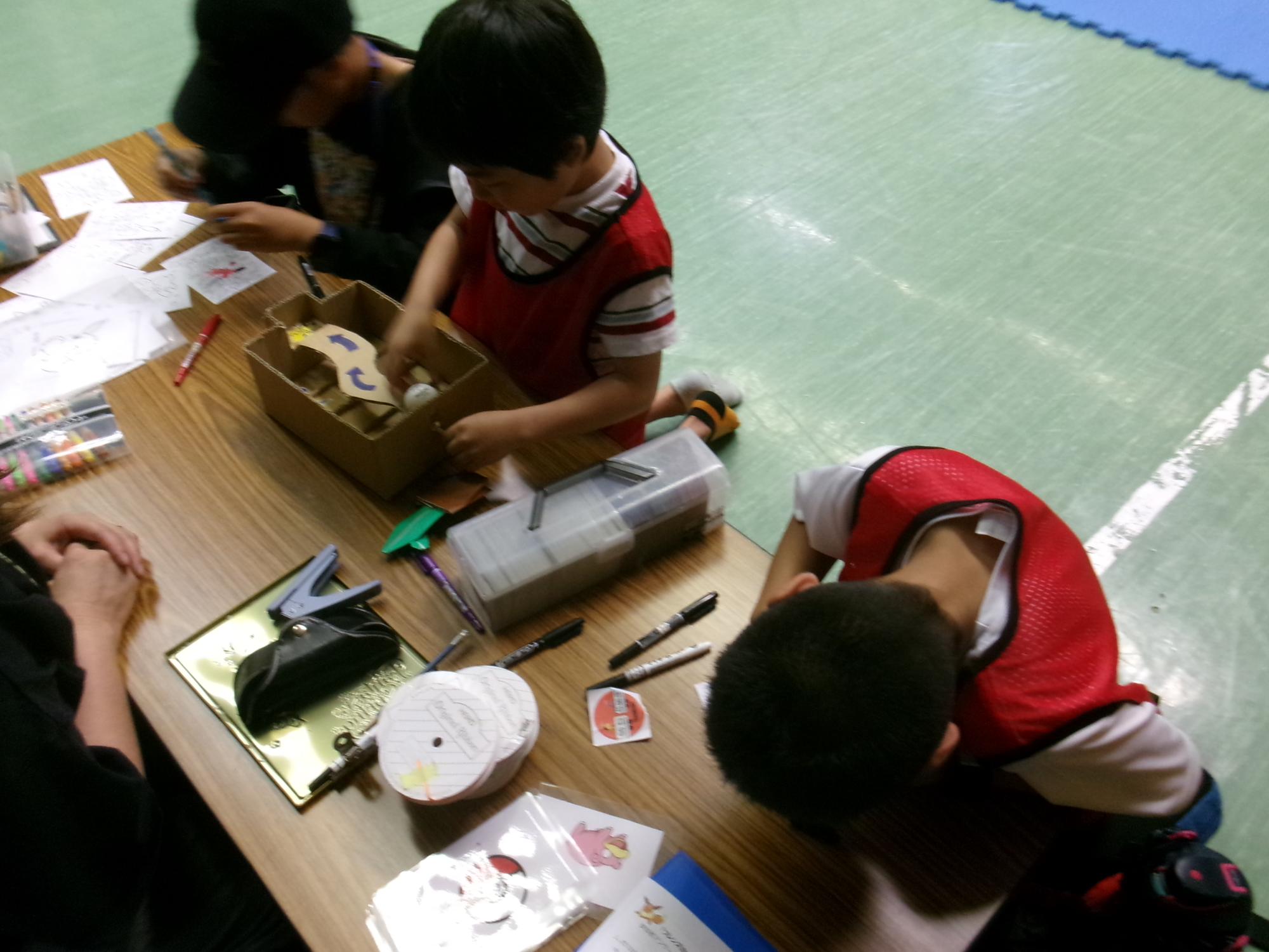 ポケカチャレンジ交流会のプラバンコーナーに参加する小学生児童の様子の写真