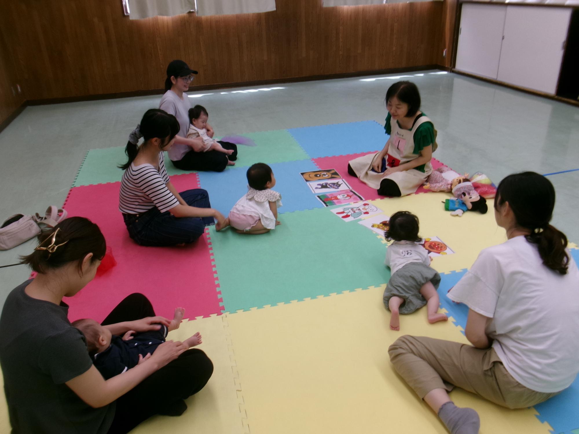 ベビーマッサージ＆リトミックの講師と参加した乳幼児親子の写真