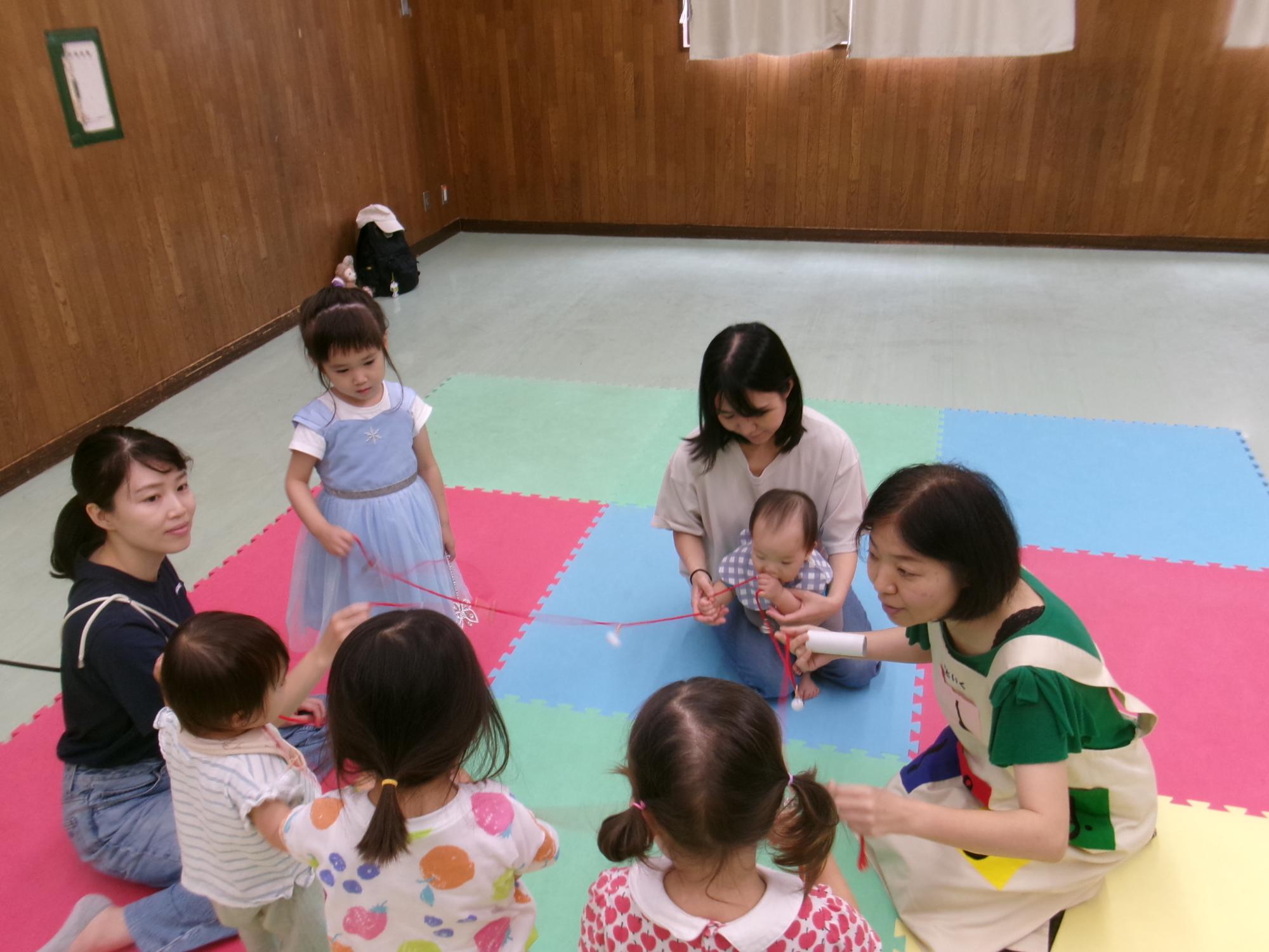 ベビーマッサージ＆リトミックの講師と参加した乳幼児親子の写真