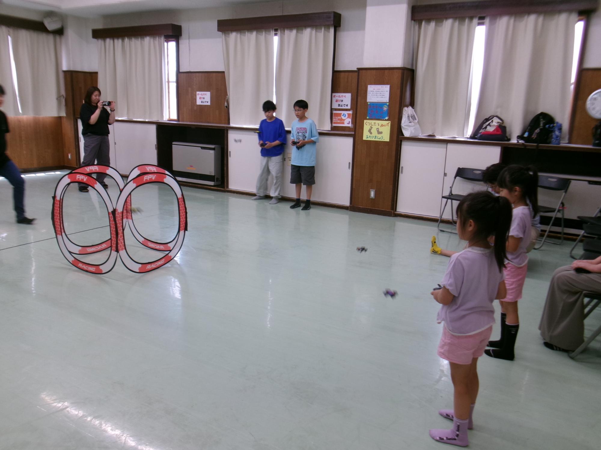 ドローン操縦を体験する小学生児童の様子の写真