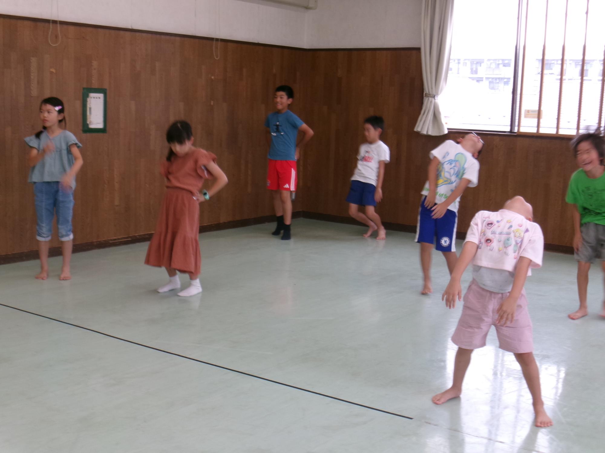 集会室で体操をする参加者の様子の写真