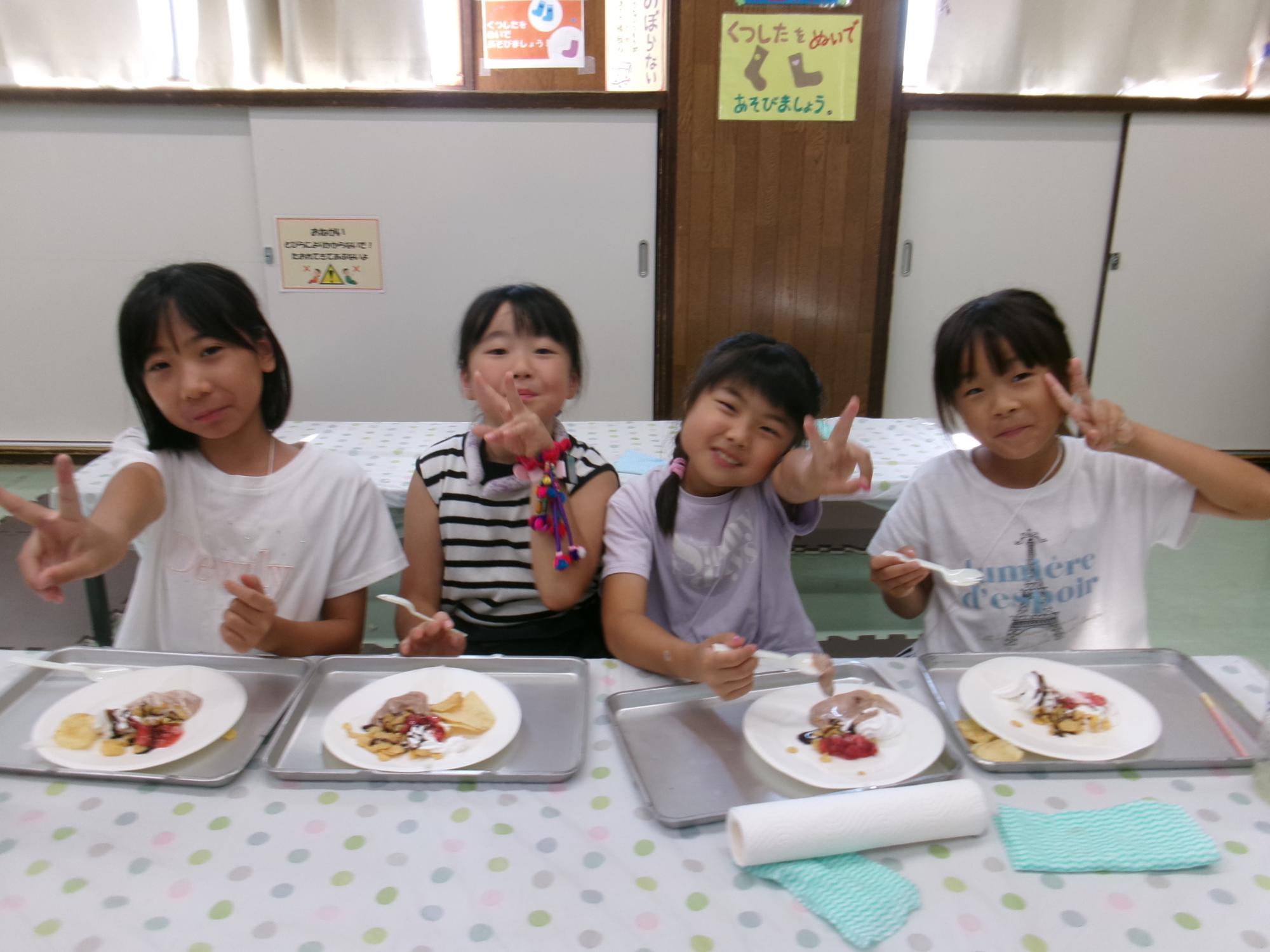 あさお食堂のミニクレープを食べる小学生児童の写真