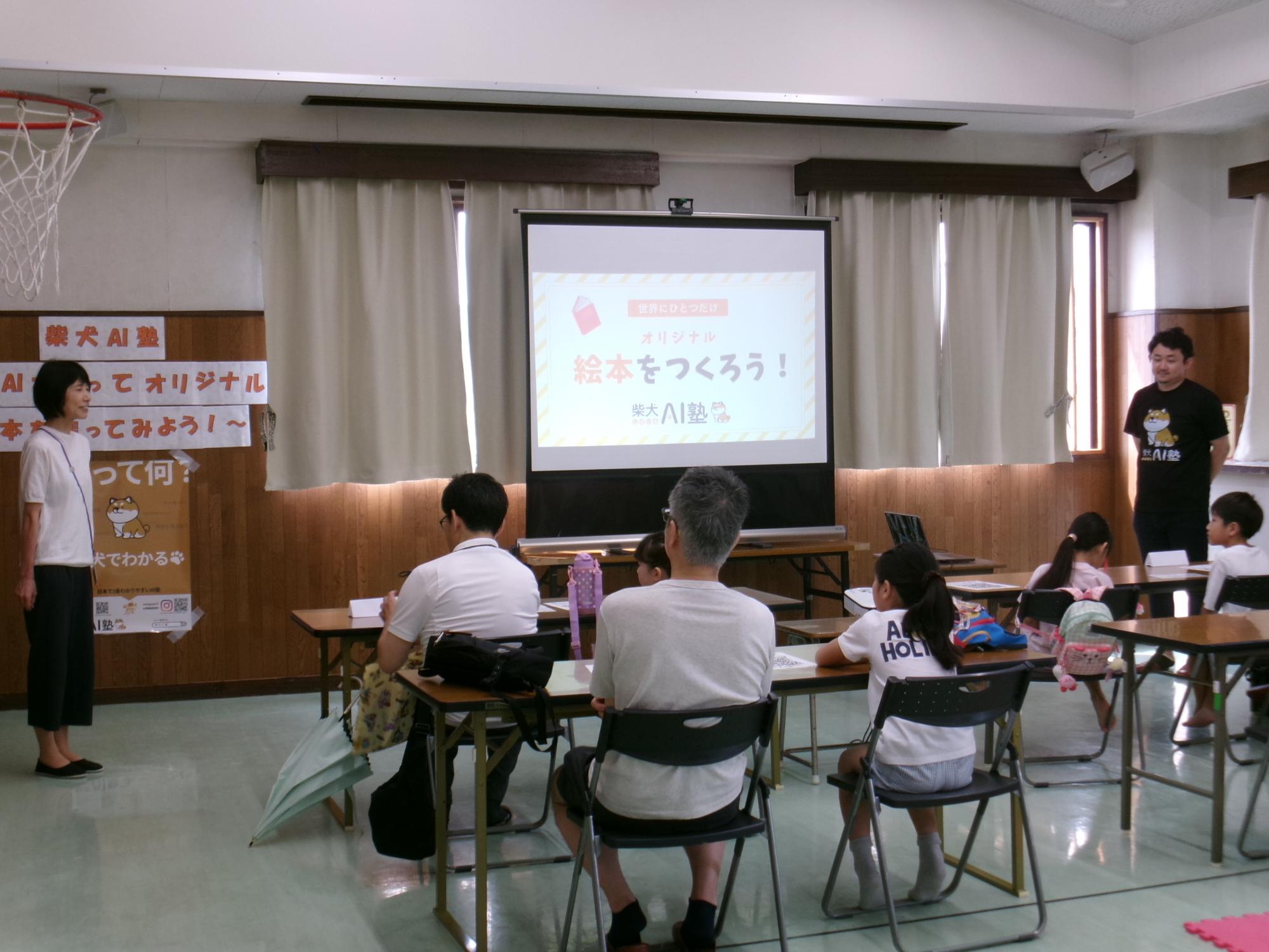 柴犬AI塾に参加する小学生親子とあいさつをする館長と講師の様子の写真