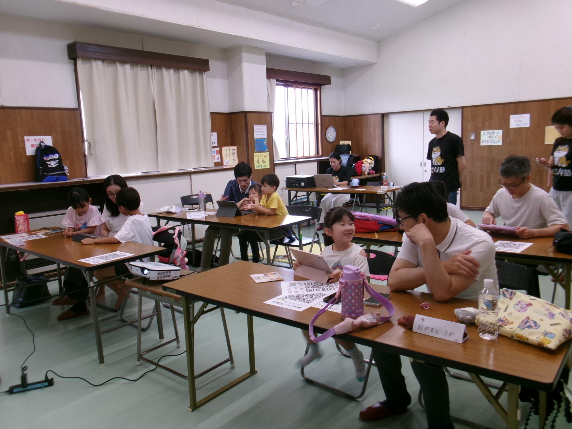 親子で相談しながらタブレットに物語の文章を打ち込む様子の写真