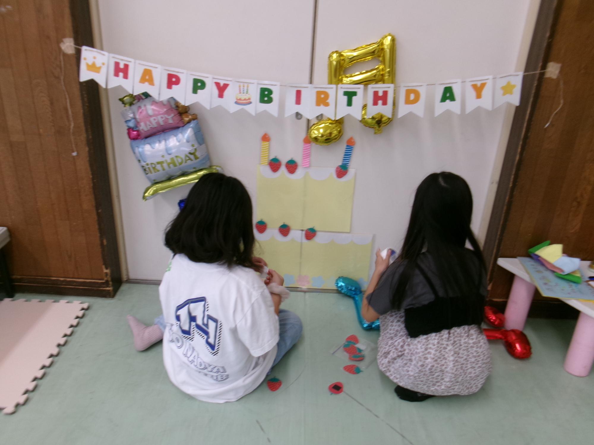 集会室の飾り付けをする小学生のボランティア児童の様子の写真