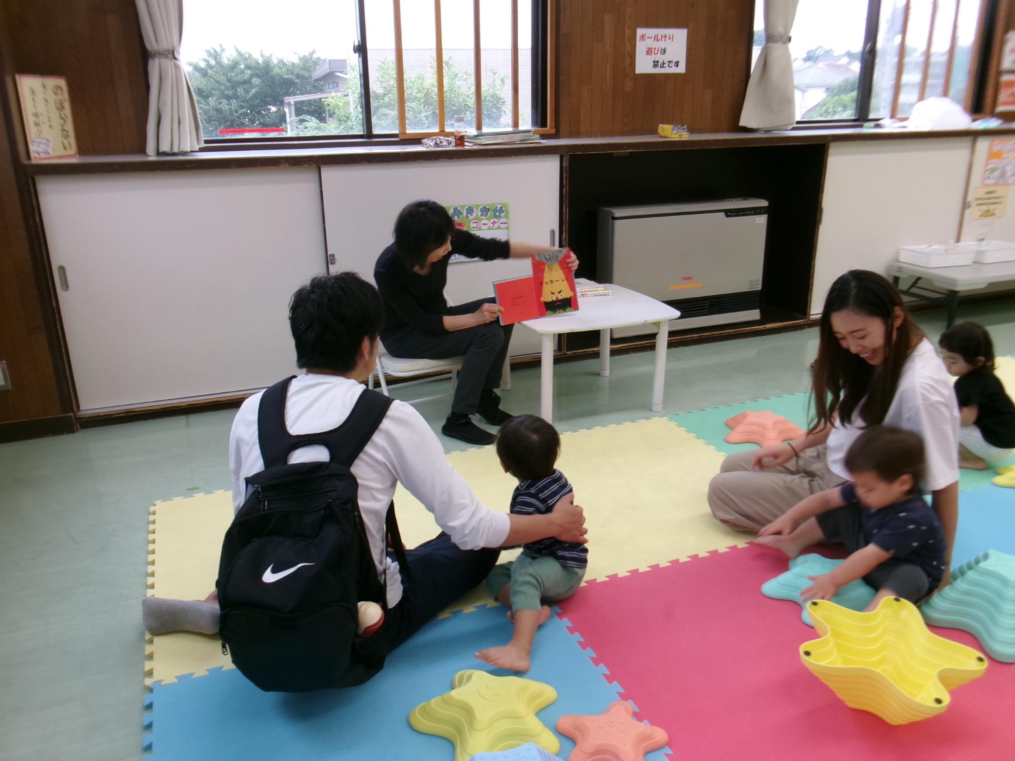 ボランティアの方による読み聞かせを聞く幼児親子の様子の写真