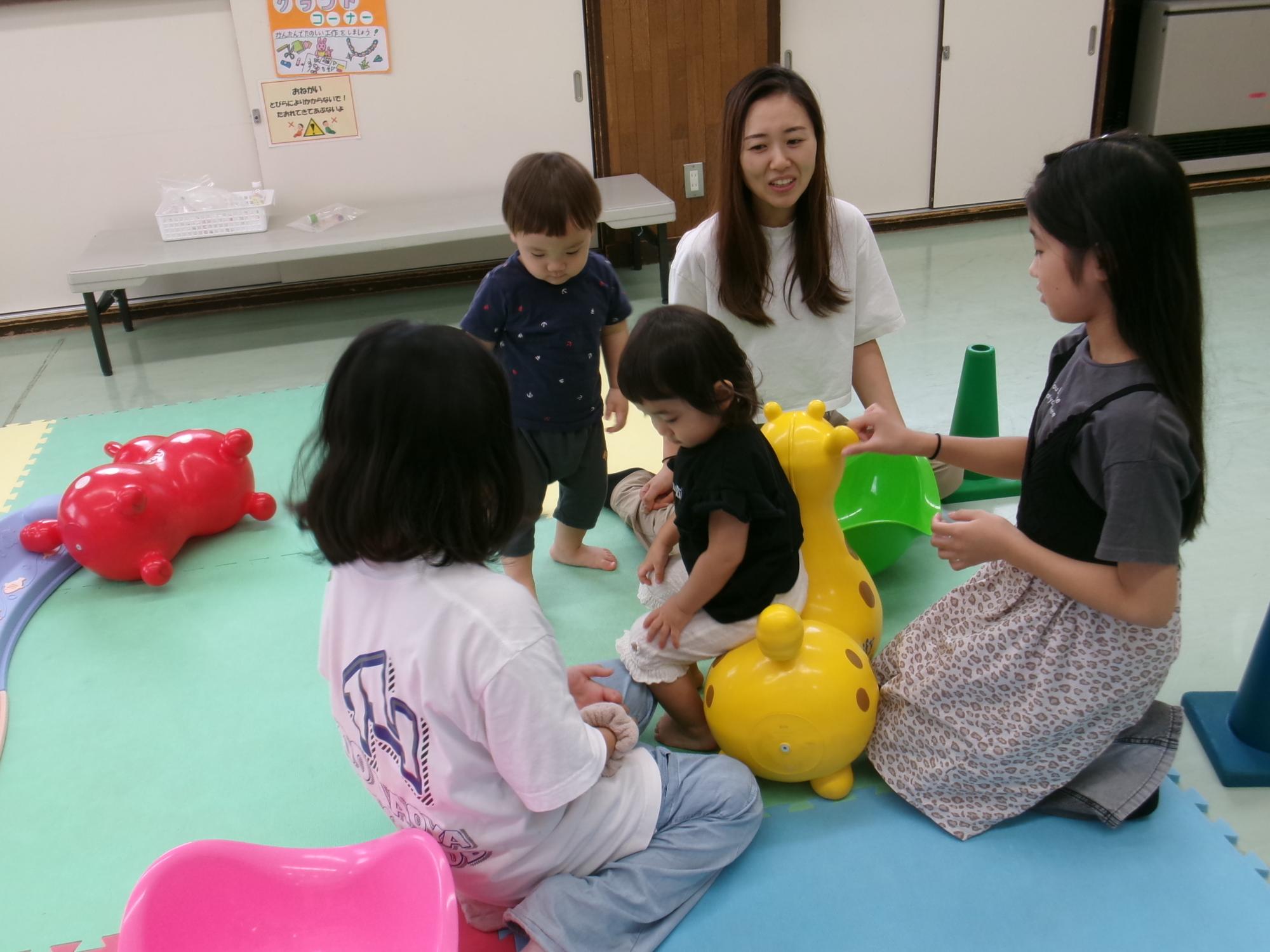 小学生ボランティアと幼児親子の交流の様子の写真