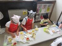 小学生がひとくちピザを作っている写真