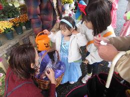 近隣のお店でお菓子とお花をもらっている写真