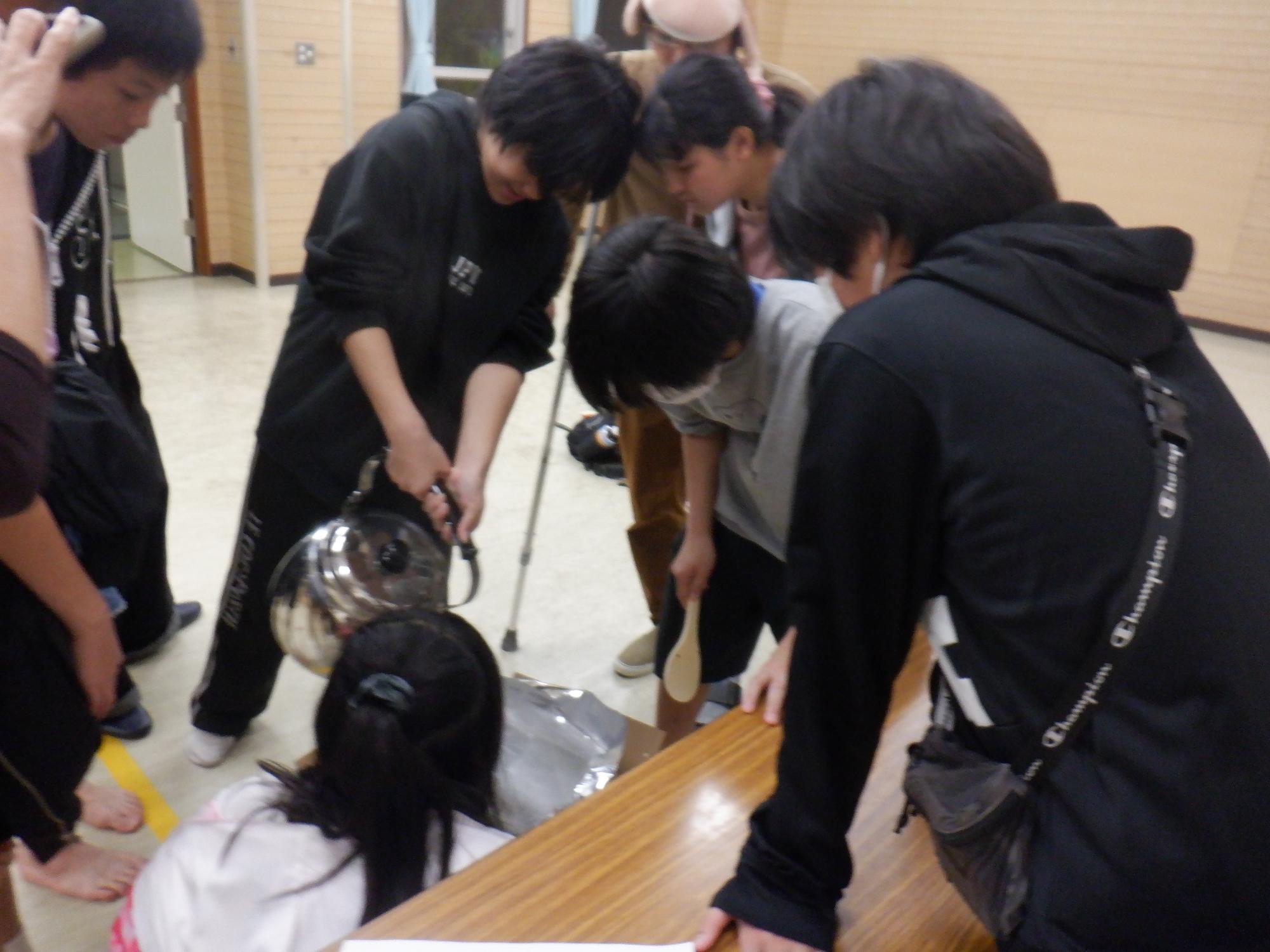 中学生がアルファ化米を調理する様子の写真