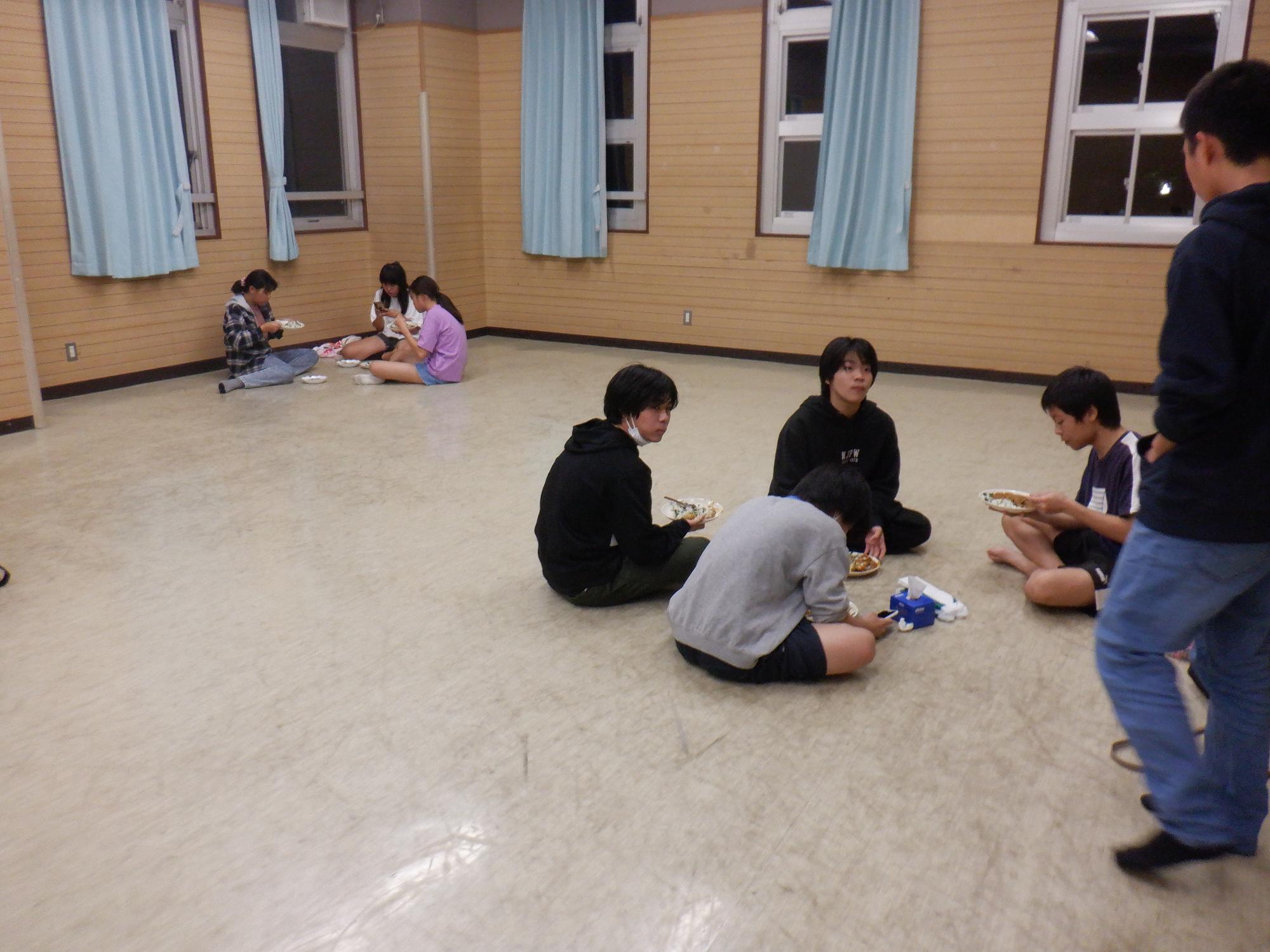 中学生が自分たちで調理したカレーを食べている様子の写真