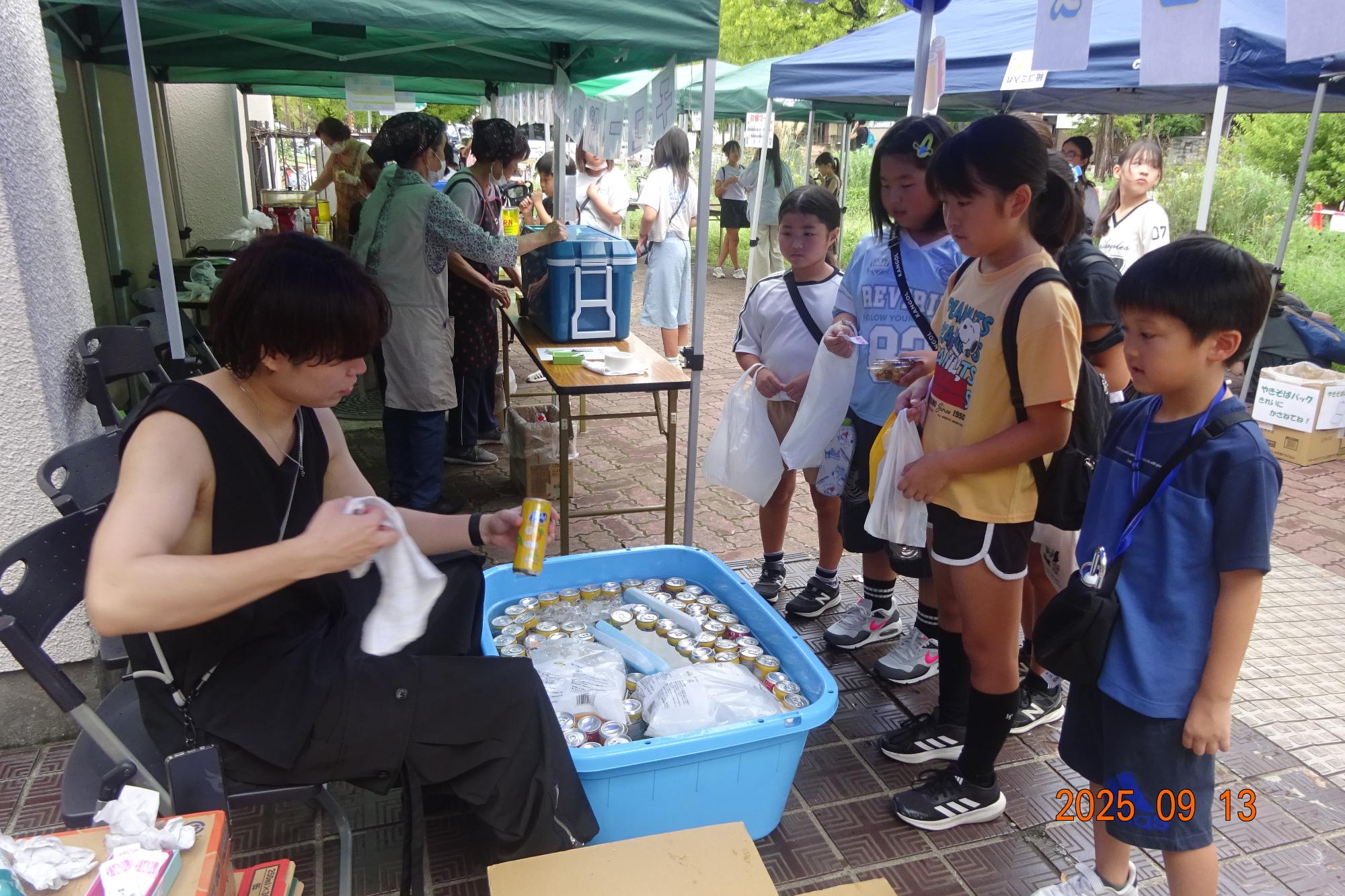 野外ブースにてジュースを引き換えている参加者の写真