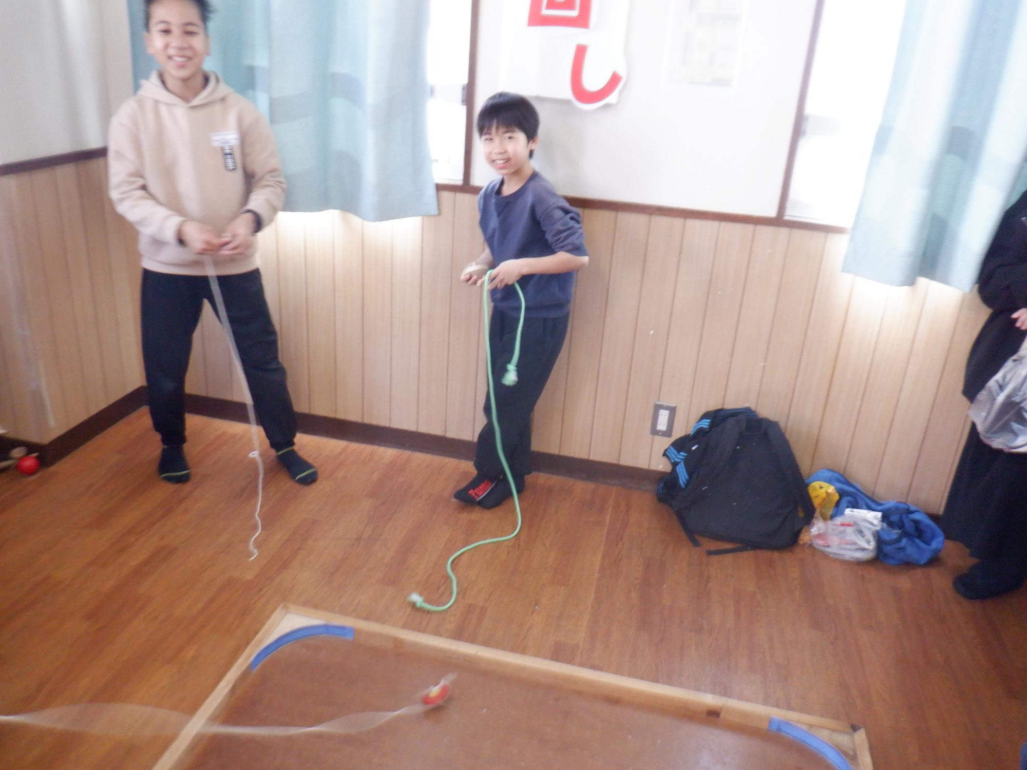 学習室でコマ回しをする小学生の写真